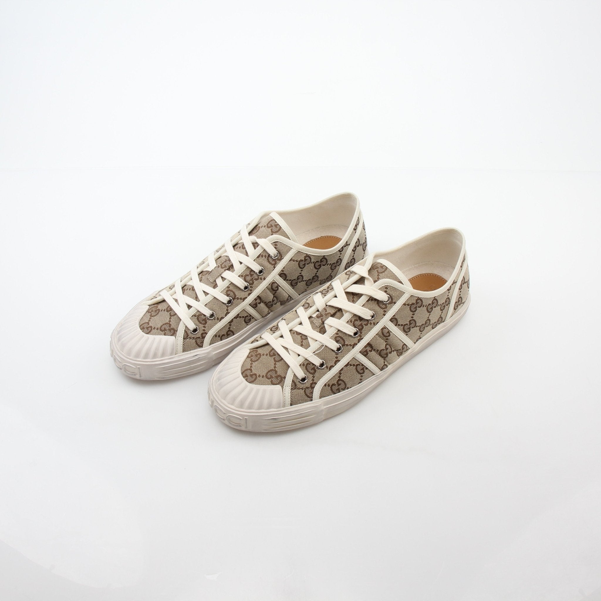 Gold & Beyond Gucci GG Supreme sneakers featuring classic logo print, white rubber soles, and stylish casual shoe design.