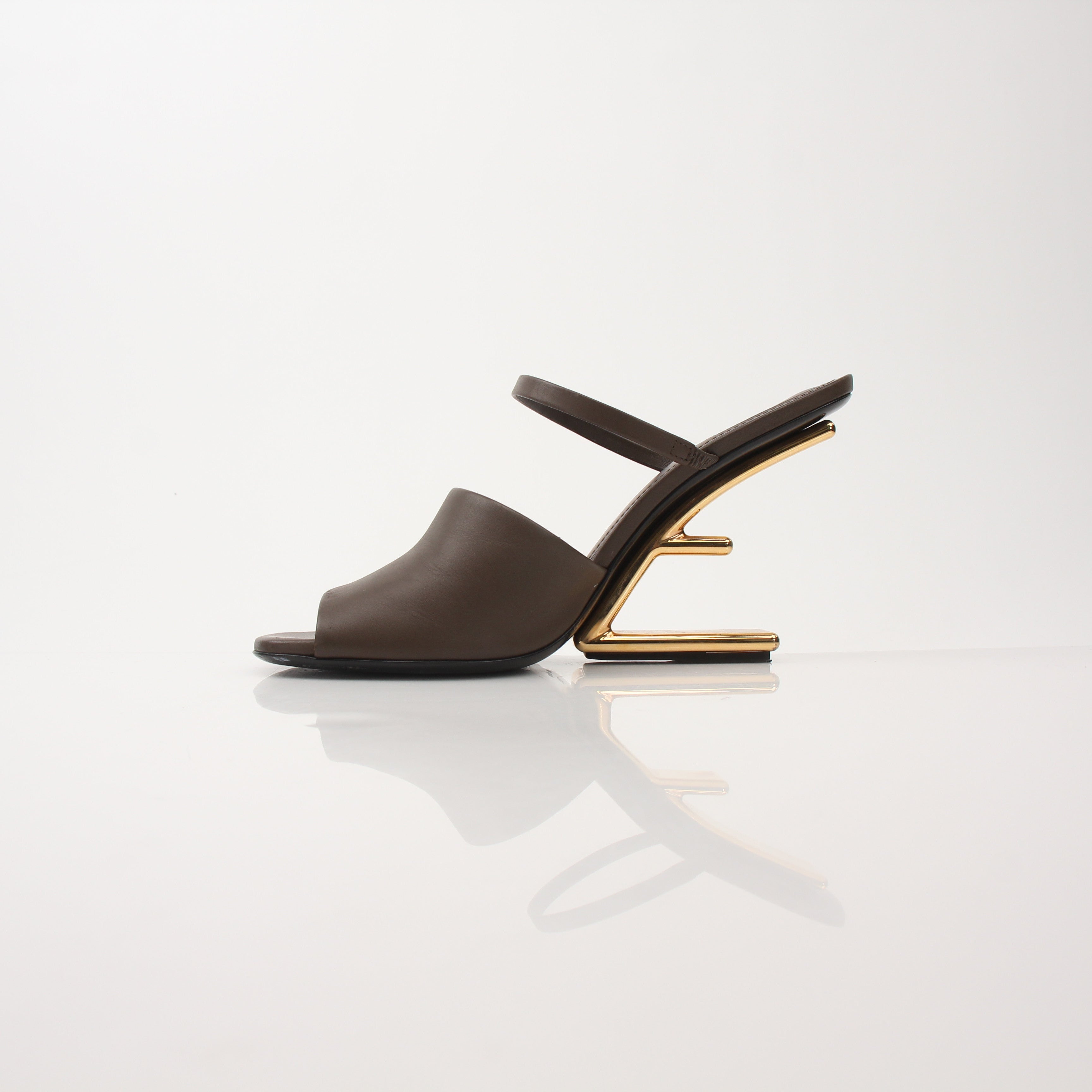 Fendi First sculpted heel sandals in beige with gold accents, featuring elegant open-toe design and slim stiletto heels.
