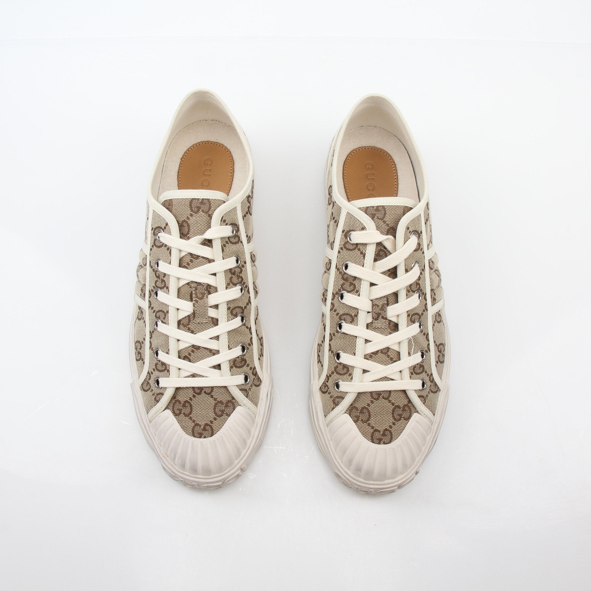 Gold & Beyond Gucci GG Supreme sneakers showing beige and brown canvas with the iconic GG pattern and white rubber soles.