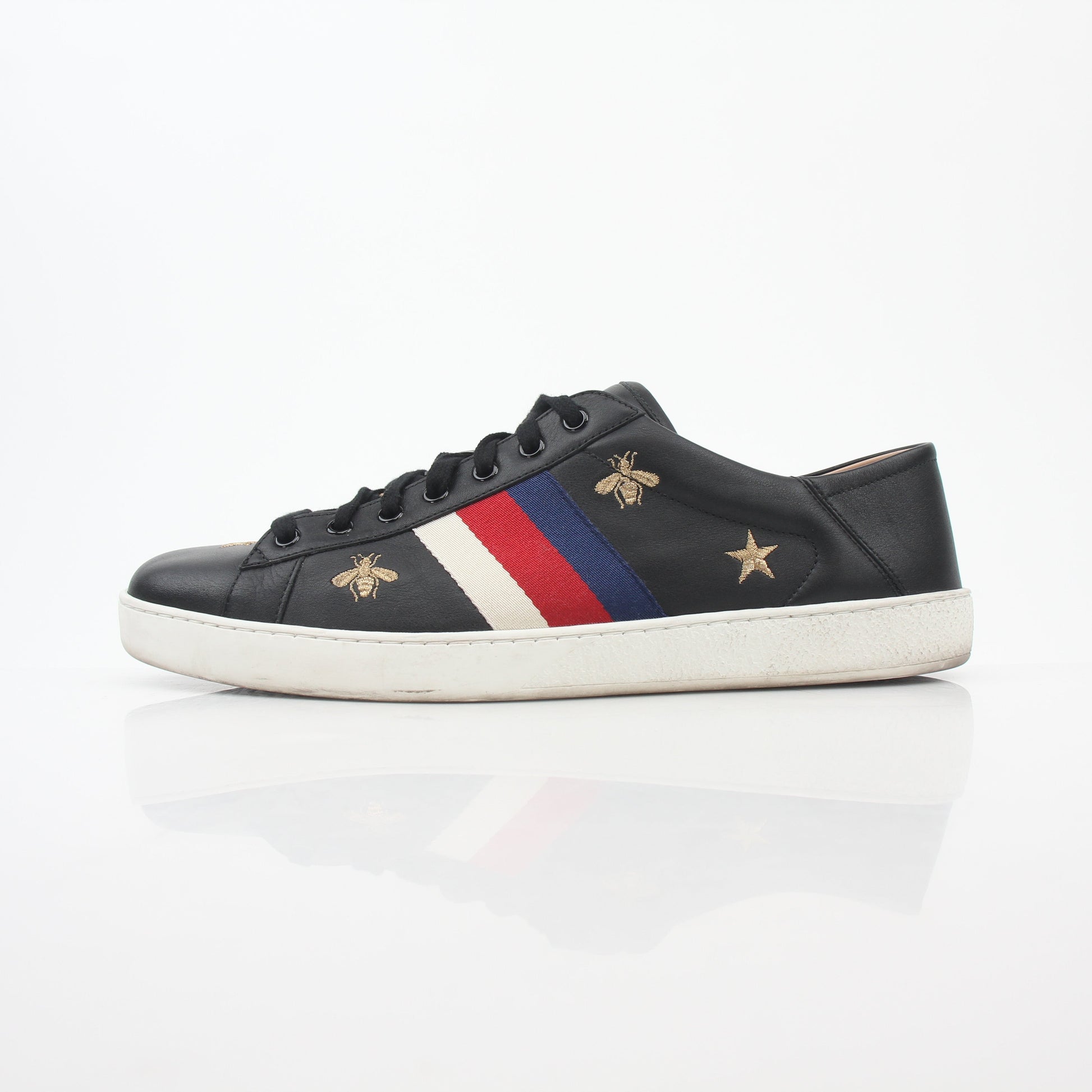 Gucci black embroidered Ace Web low-top sneakers with white sole and signature details, displayed on a neutral background.
