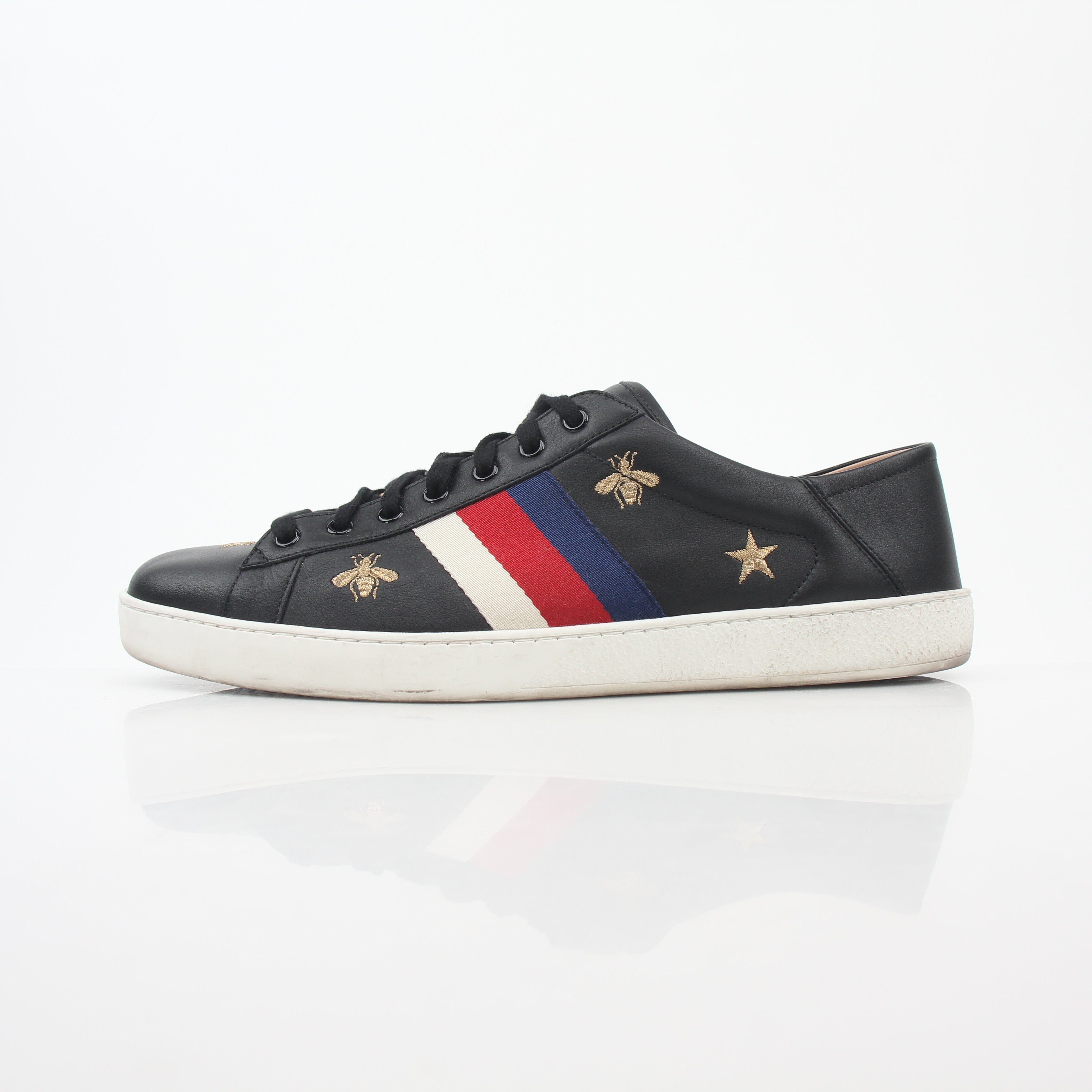 Gucci black embroidered Ace Web low-top sneakers with white sole and signature details, displayed on a neutral background.