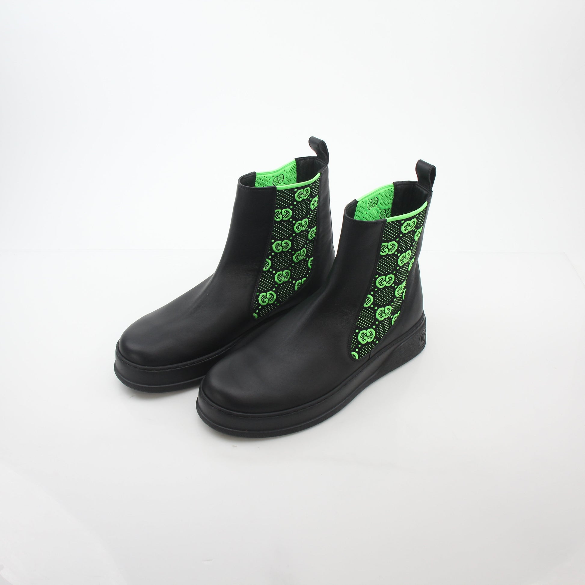Gucci black and neon green GG Dali ankle boots with sleek design, featuring bold color blocking and stylish high-heeled shoes.