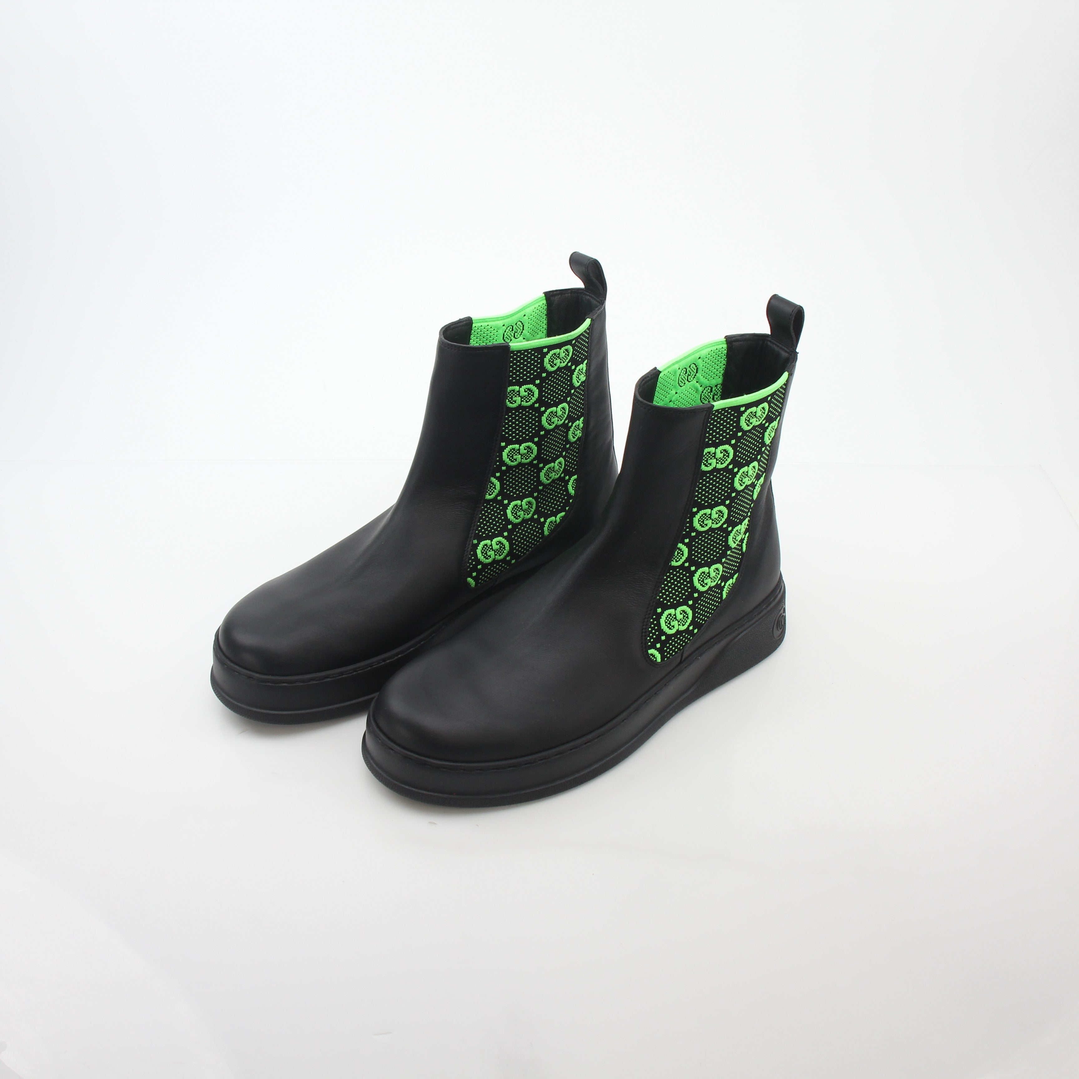 Gucci black and neon green GG Dali ankle boots with sleek design, featuring bold color blocking and stylish high-heeled shoes.