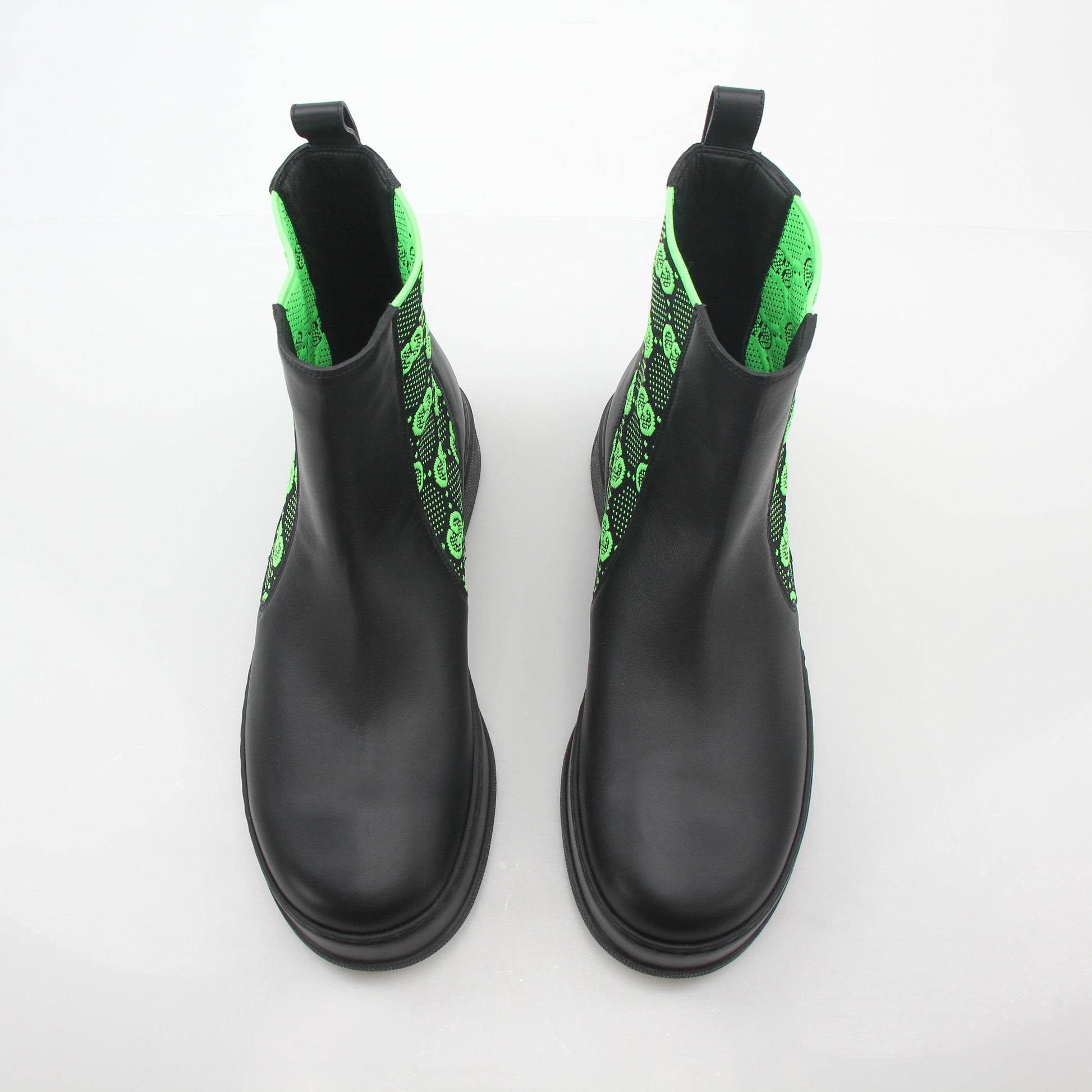 Gucci black and neon green GG Dali ankle boots, stylish shoes with bold color accents and logo details, on a neutral background.