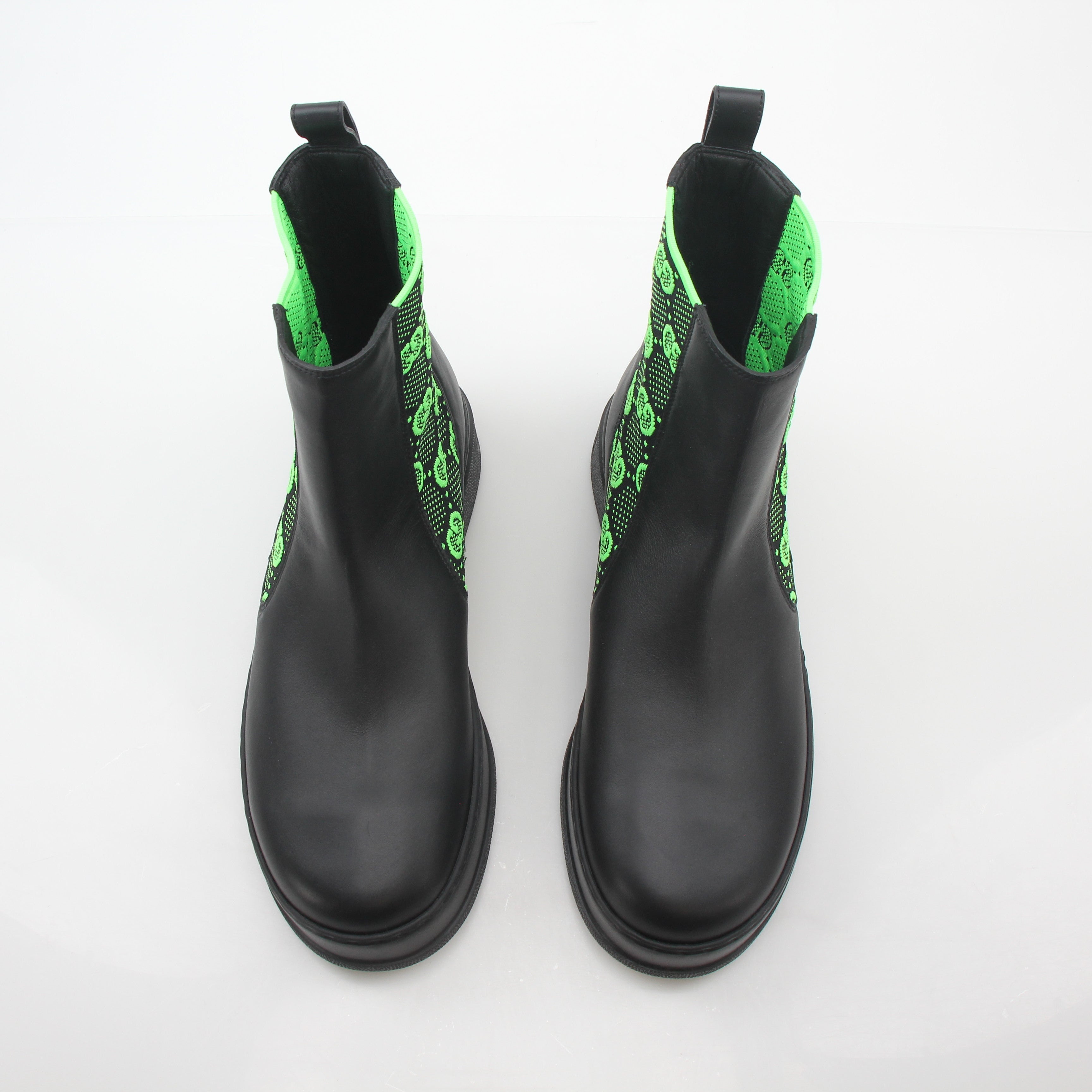 Gucci black and neon green GG Dali ankle boots, stylish shoes with bold color accents and logo details, on a neutral background.