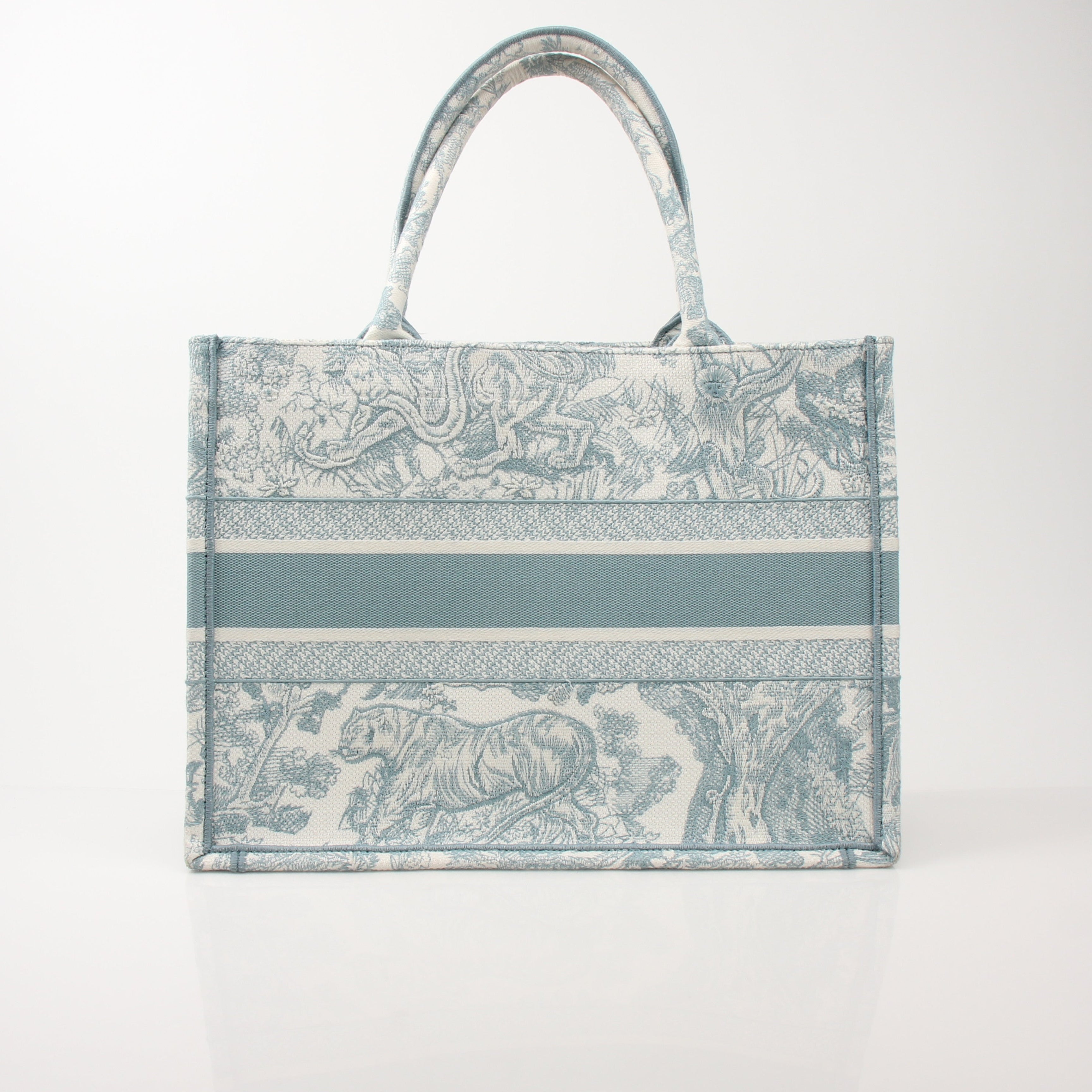 Christian Dior Toile de Jouy Book Tote handbag with white and blue patterned fabric and leather handles.
