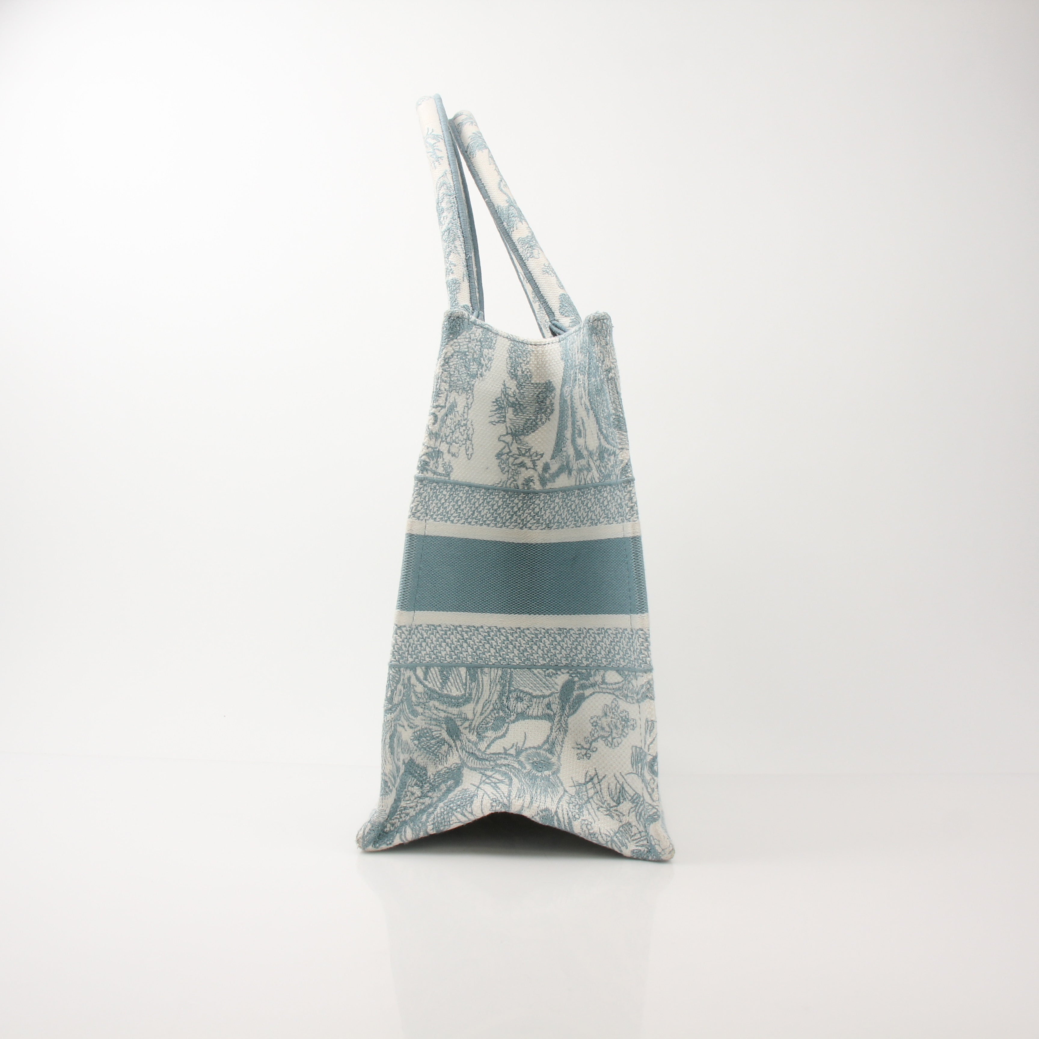 Christian Dior Toile de Jouy Book Tote handbag with white and blue floral pattern, featuring leather handles and structured design.