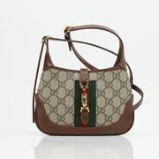 Gucci Jackie 1961 Mini handbag with beige and brown GG canvas, leather trim, and gold-tone hardware, showing front view.