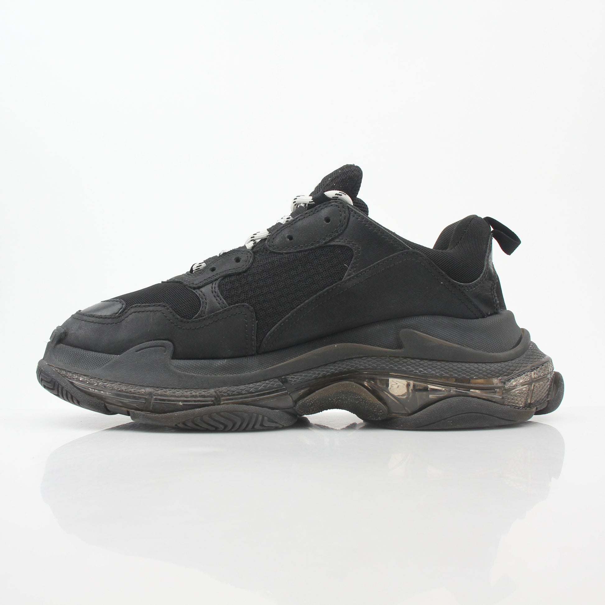 Balenciaga Black Triple S sneakers with clear soles, showcasing chunky design and brand logo on the shoes.