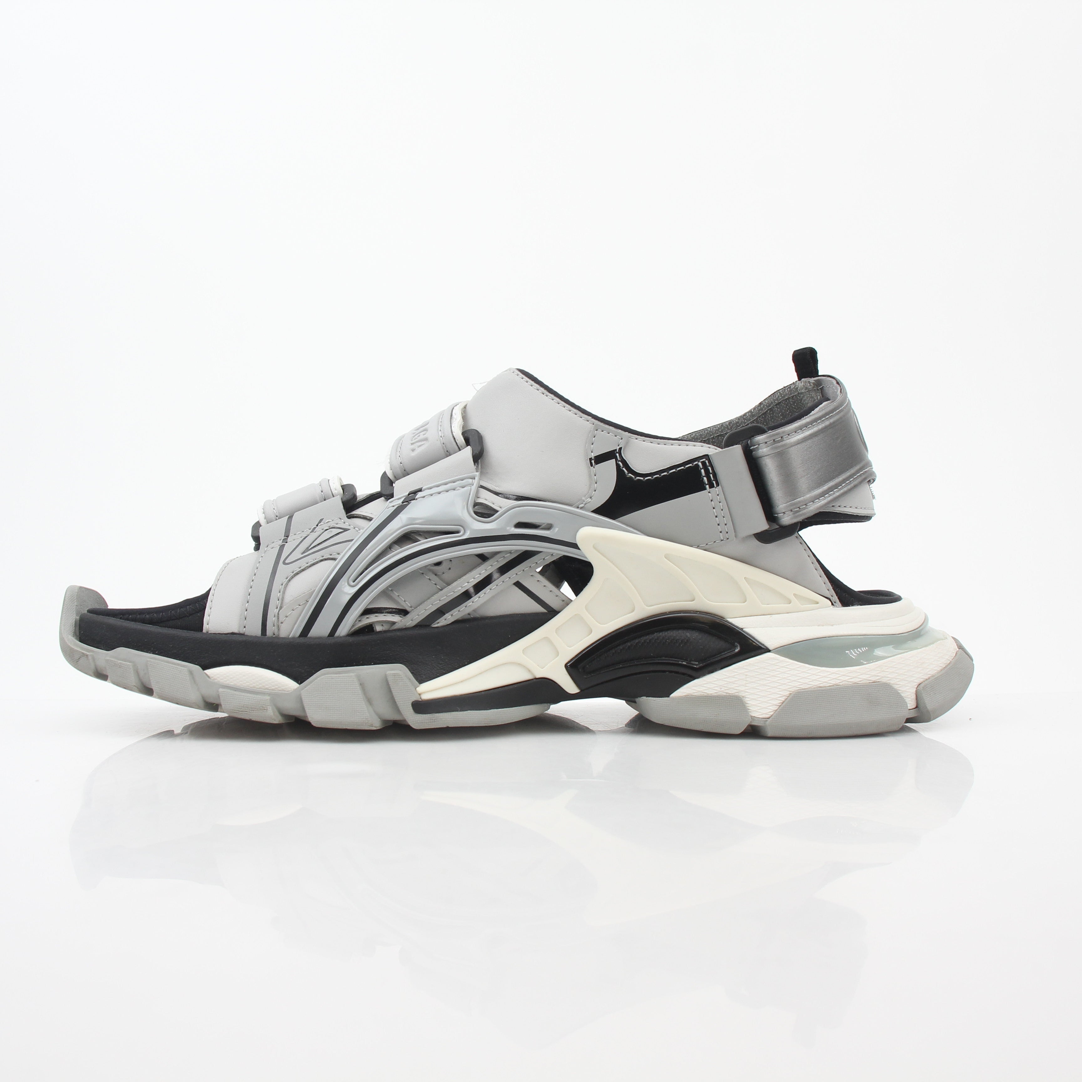 Gray Balenciaga track sandals featuring sporty design and chunky sole, worn on a model's feet.