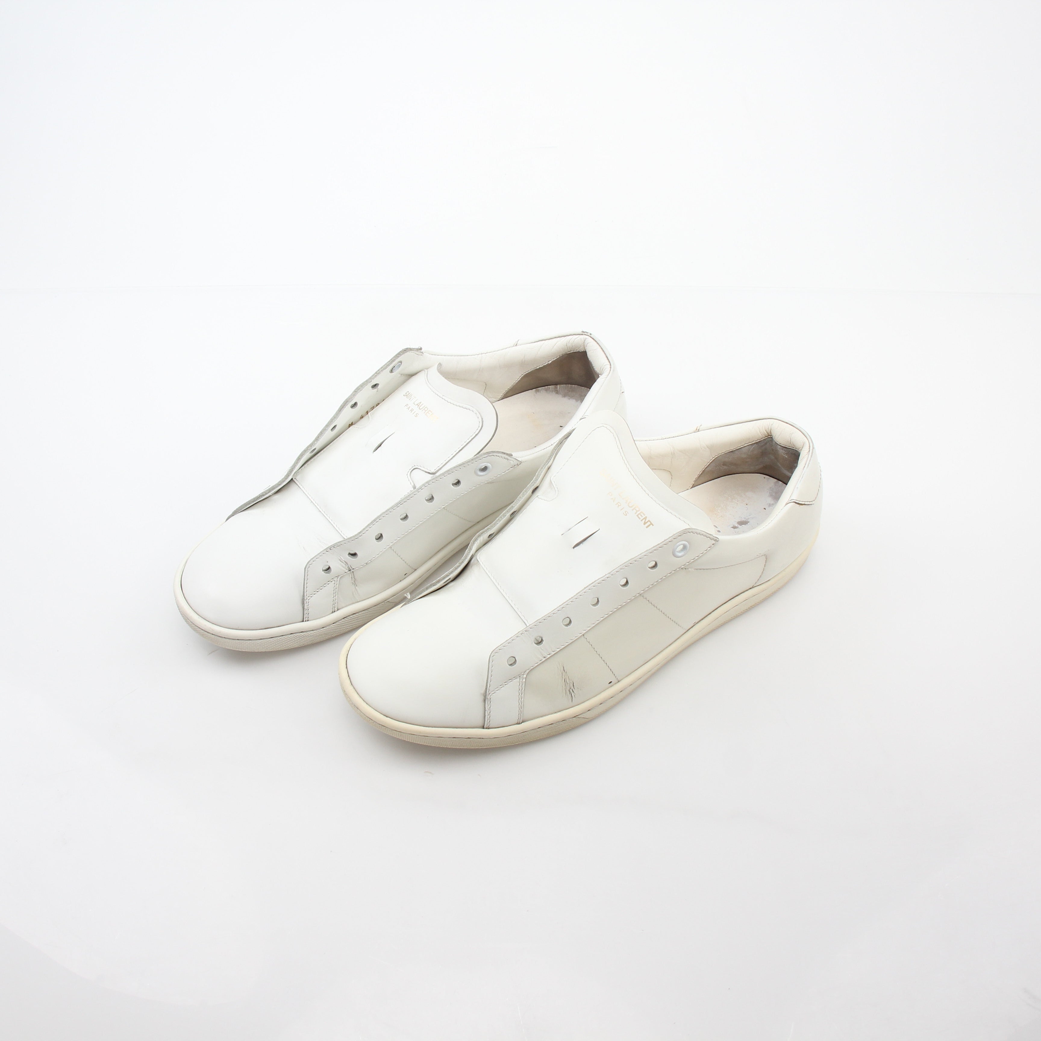 White Saint Laurent SL/06 Court Classic sneakers with gold accents, featuring a sleek low-top design and stylish branding.