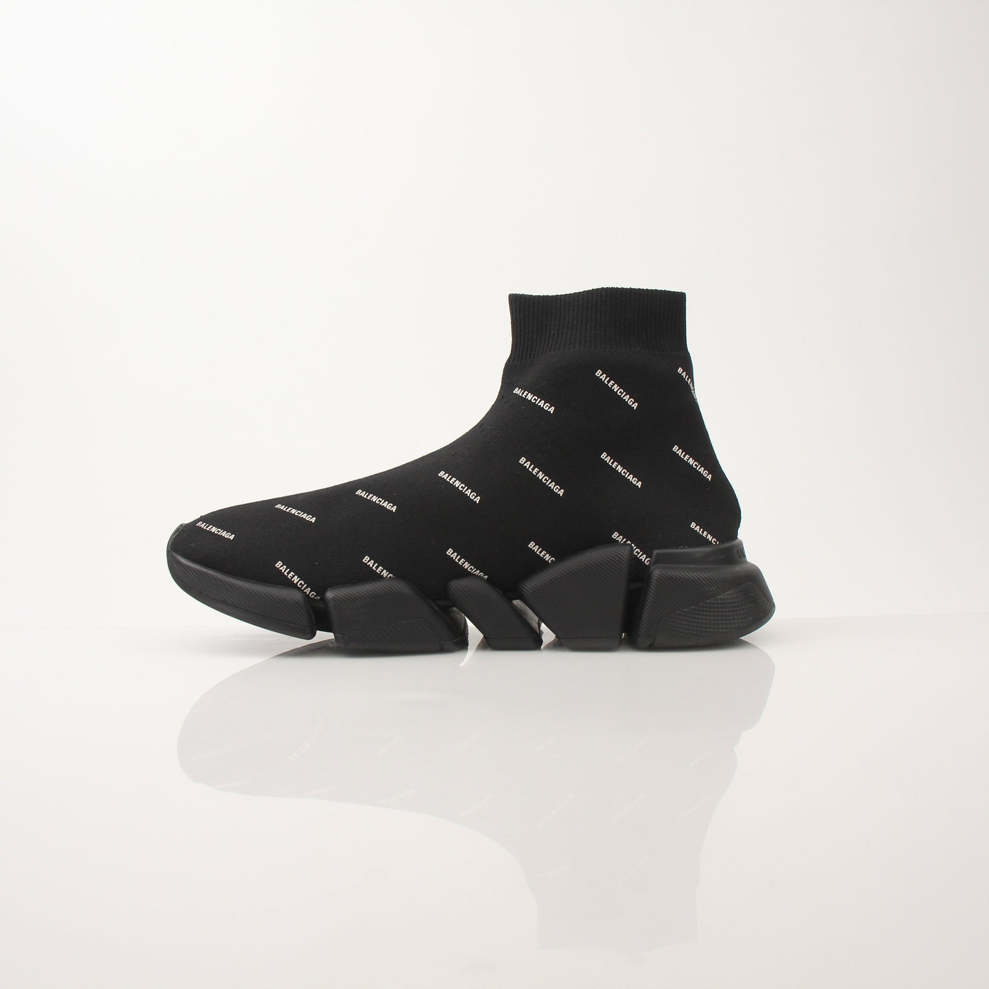 Gold & Beyond Balenciaga Women’s All Over Logo Speed 2.0 sneakers showing white shoes with bold logo print on the sides.