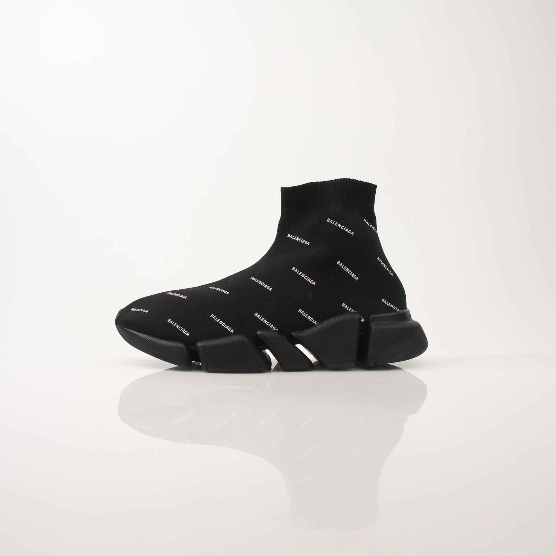 Gold & Beyond women's Balenciaga Speed 2.0 sneakers with all-over logo design, showcasing stylish black and white athletic shoes.
