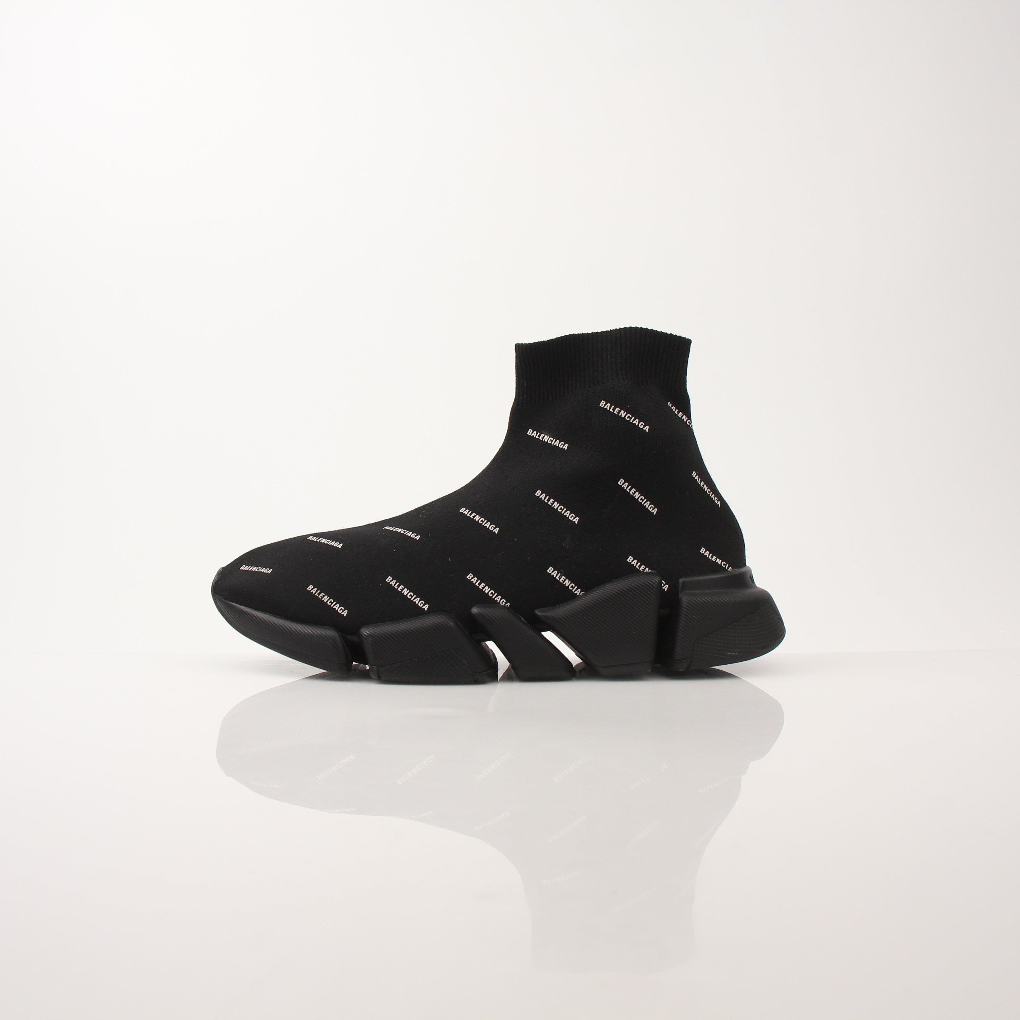 Gold & Beyond women's Balenciaga Speed 2.0 sneakers with all-over logo design, showcasing stylish black and white athletic shoes.