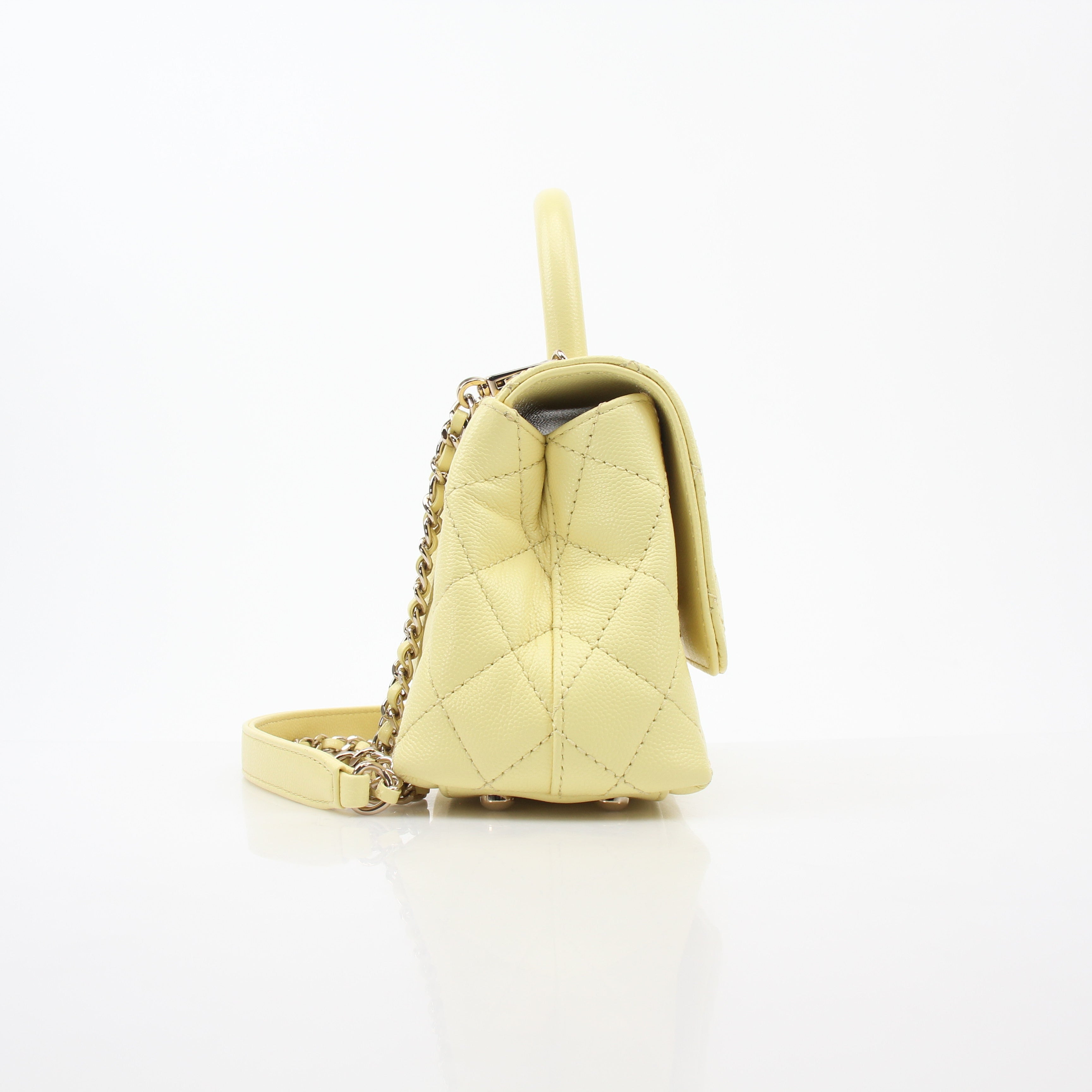 Yellow Chanel Mini Coco Handle Flap Bag, gold hardware, with quilted leather and signature Chanel design details.