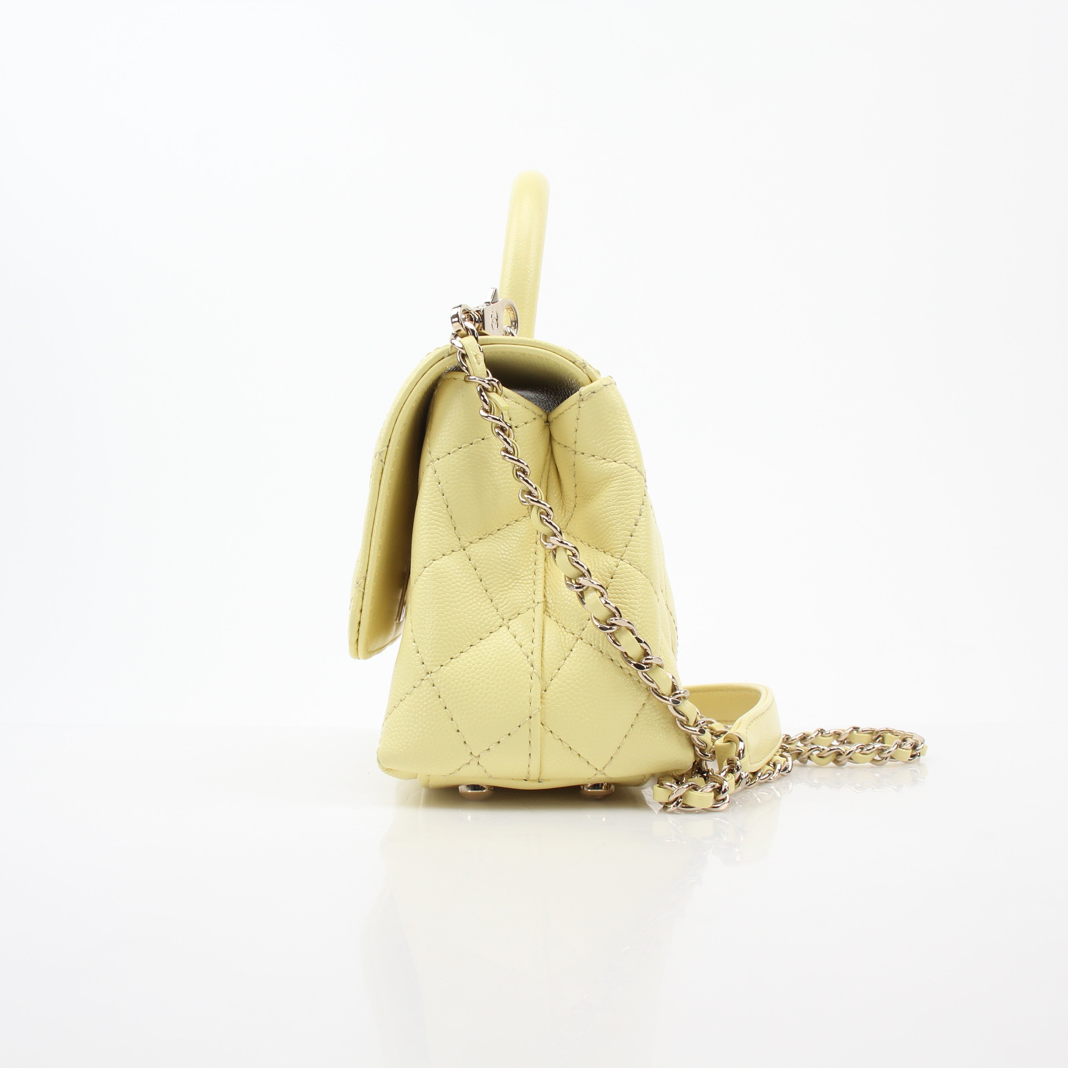 Gold & Beyond Chanel Yellow Mini Coco Handle Flap Bag handbag with gold hardware and signature quilted design on a white background.