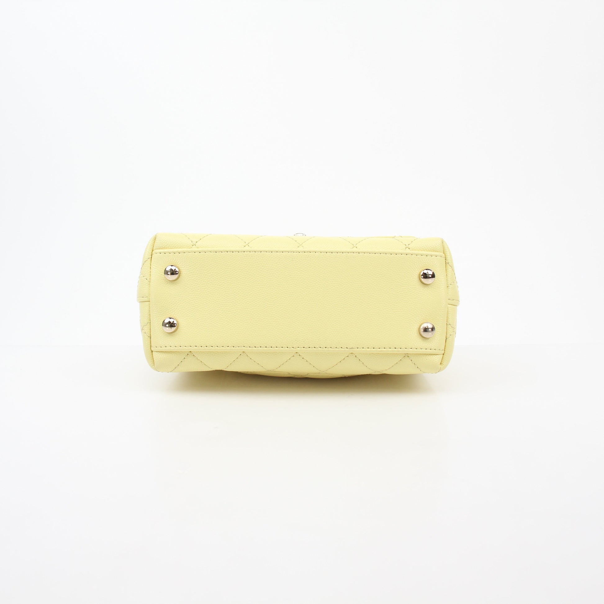 Yellow Chanel Mini Coco Handle Flap Bag with gold accents, showcasing its elegant handbag design and signature quilted pattern.