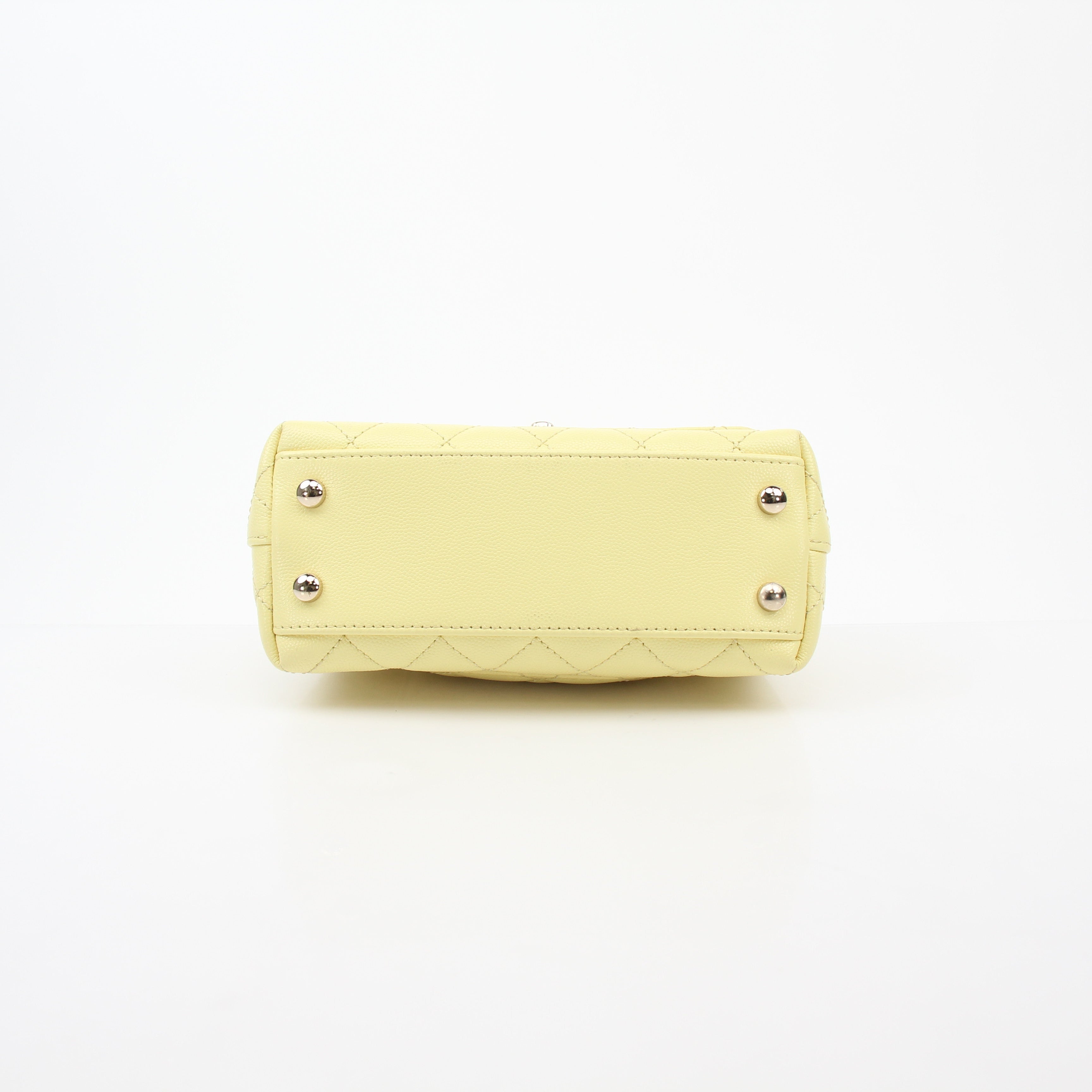 Yellow Chanel Mini Coco Handle Flap Bag with gold accents, showcasing its elegant handbag design and signature quilted pattern.