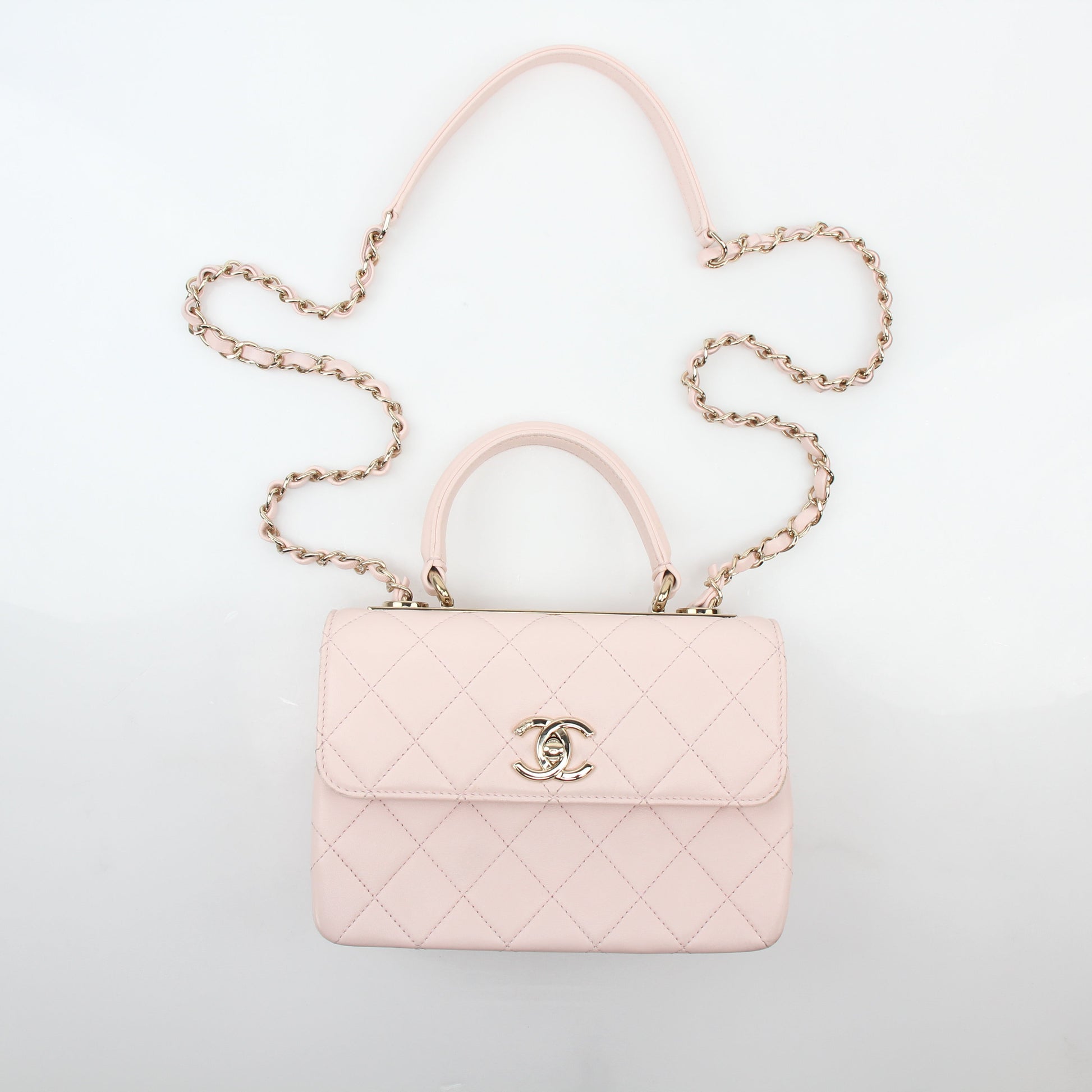 Chanel pink small trendy CC flap handbag with top handle on a gold chain, stylish and compact for elegant carrying.