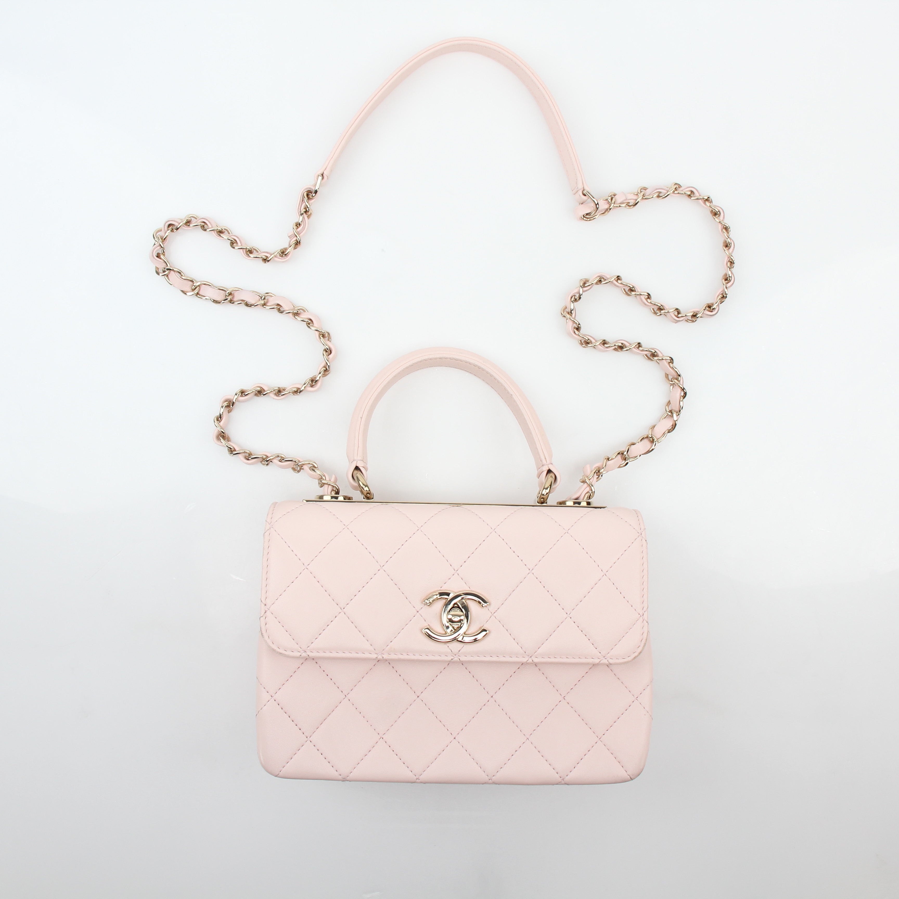 Chanel pink small trendy CC flap handbag with top handle on a gold chain, stylish and compact for elegant carrying.