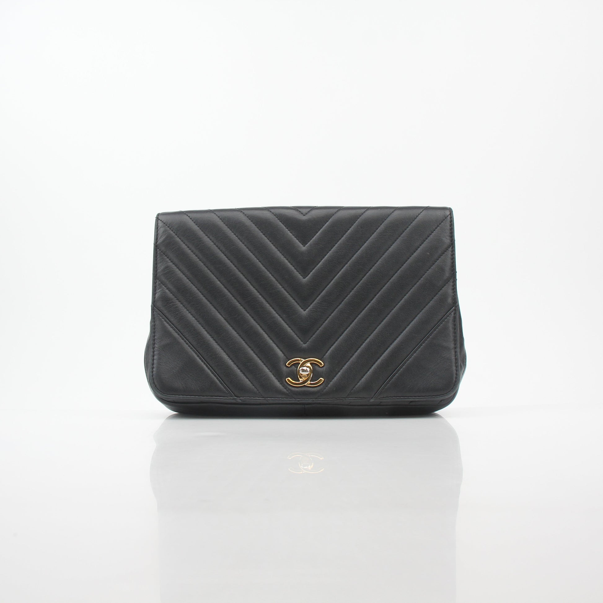 Chanel black chevron statement flap handbag with gold accents, featuring a structured design and signature quilted pattern.