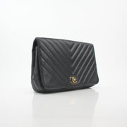 Gold & Beyond Chanel black chevron flap handbag with signature quilted pattern and gold-tone hardware, stylish and elegant.