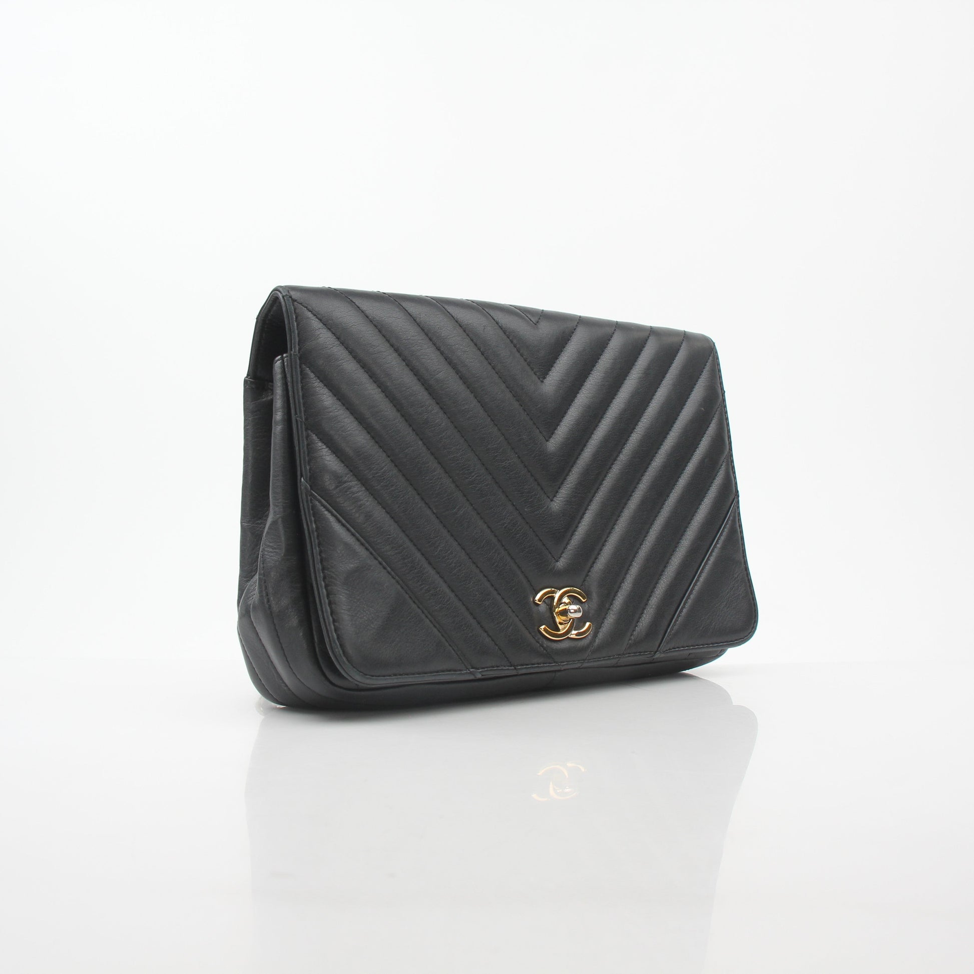 Gold & Beyond Chanel black chevron flap handbag with signature quilted pattern and gold-tone hardware, stylish and elegant.