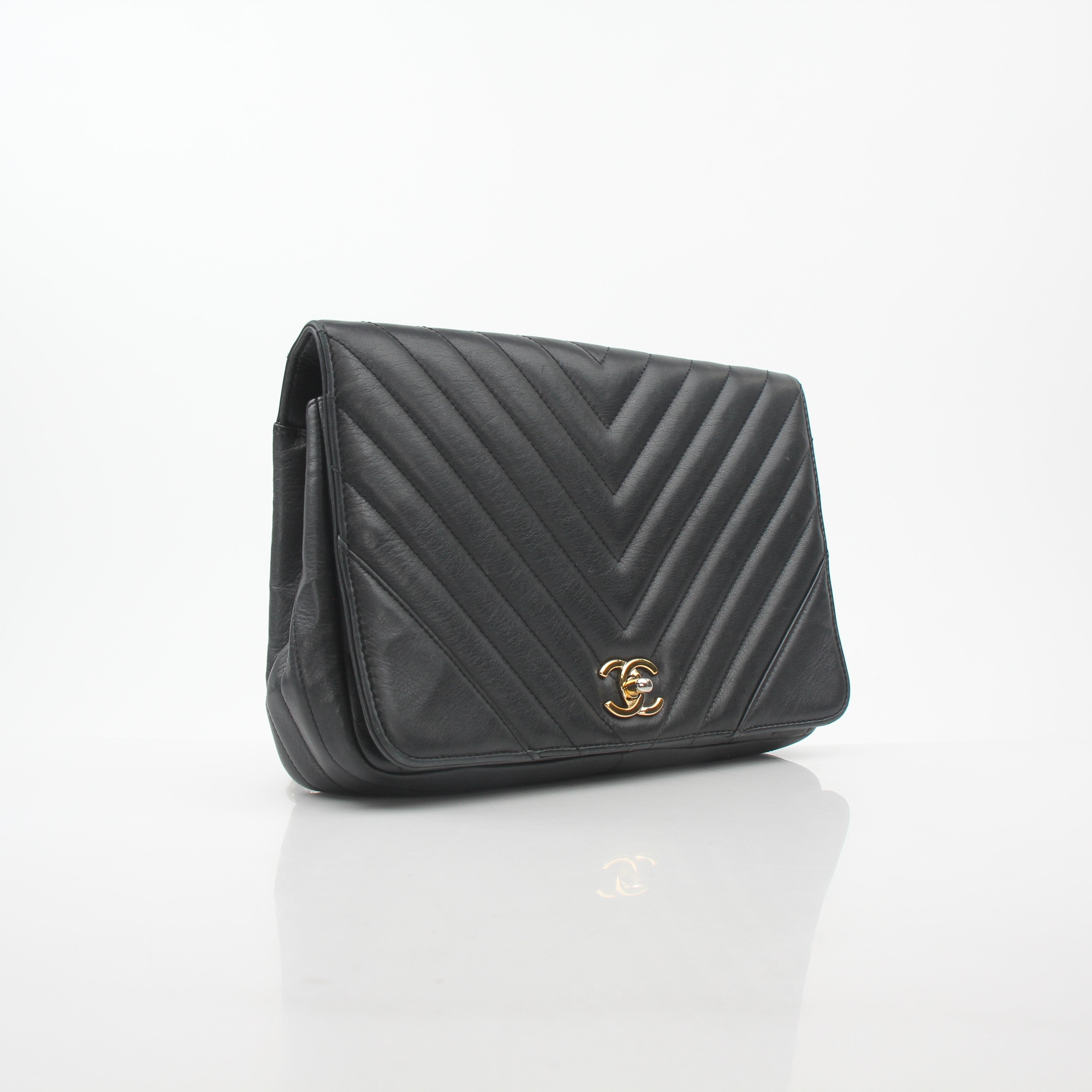 Gold & Beyond Chanel black chevron flap handbag with signature quilted pattern and gold-tone hardware, stylish and elegant.