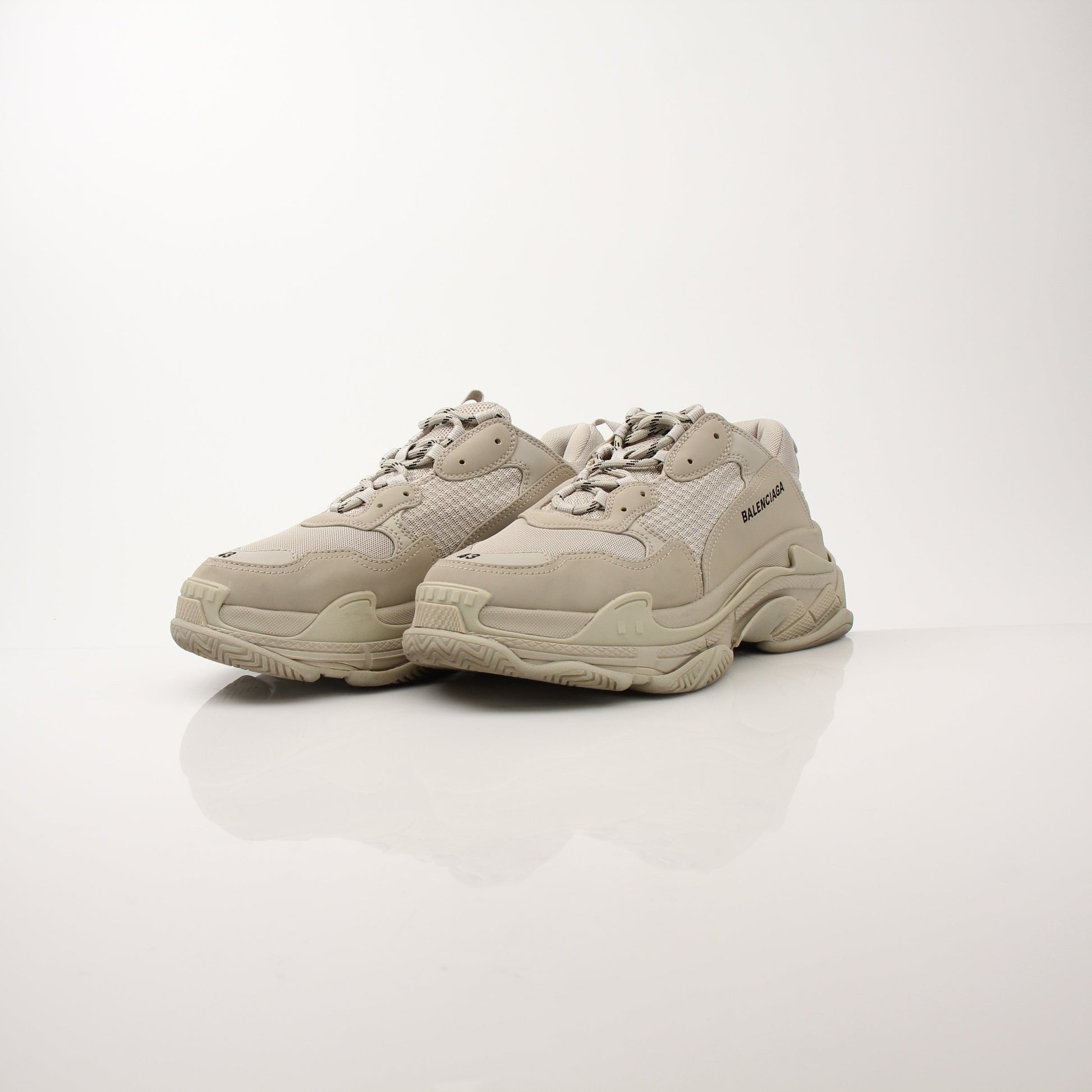 Gold & Beyond men's Balenciaga Triple S sneakers, stylish white and beige athletic shoes with chunky soles and branding details.