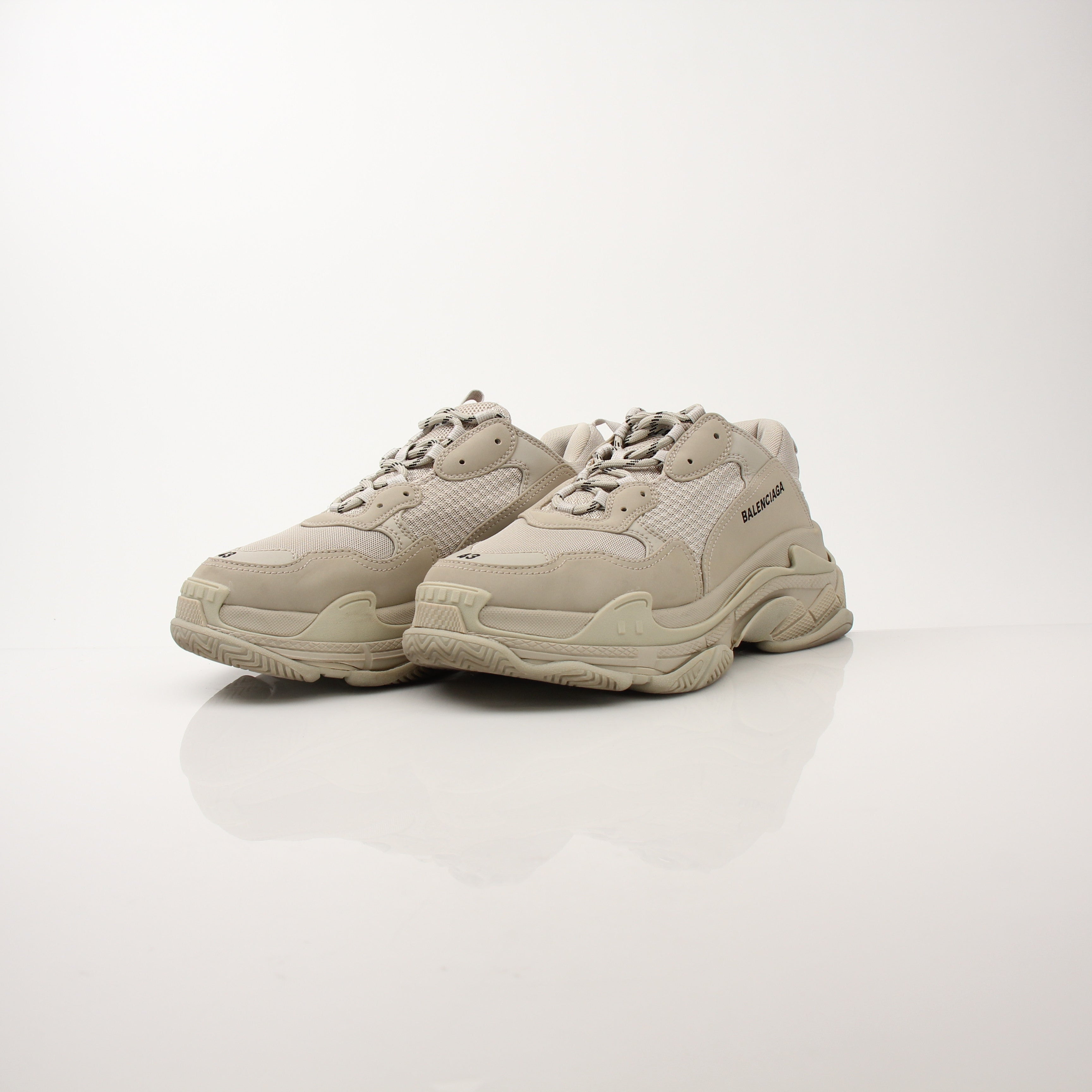 Gold & Beyond men's Balenciaga Triple S sneakers, stylish white and beige athletic shoes with chunky soles and branding details.