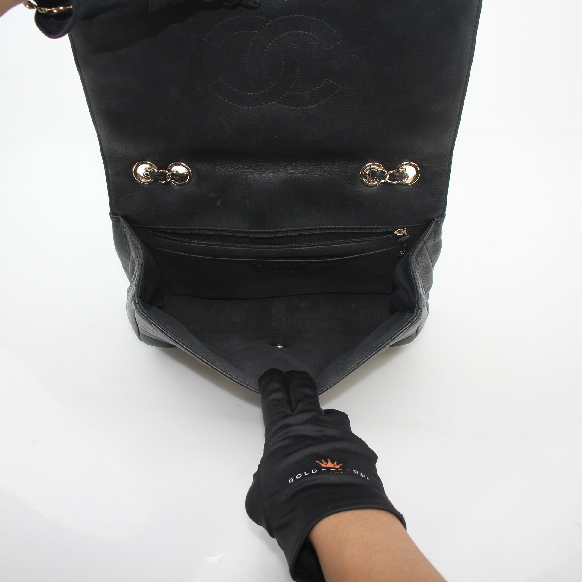 Chanel black chevron flap handbag with gold chain strap and logo clasp, stylish designer handbag by Gold & Beyond