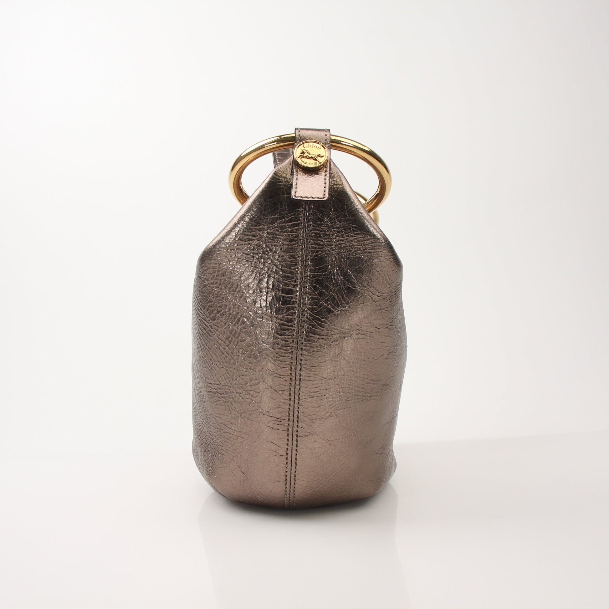 Chloé Nile bracelet metallic bucket bag, stylish handbag with gold accents and a distinctive bucket shape, featuring the brand logo.