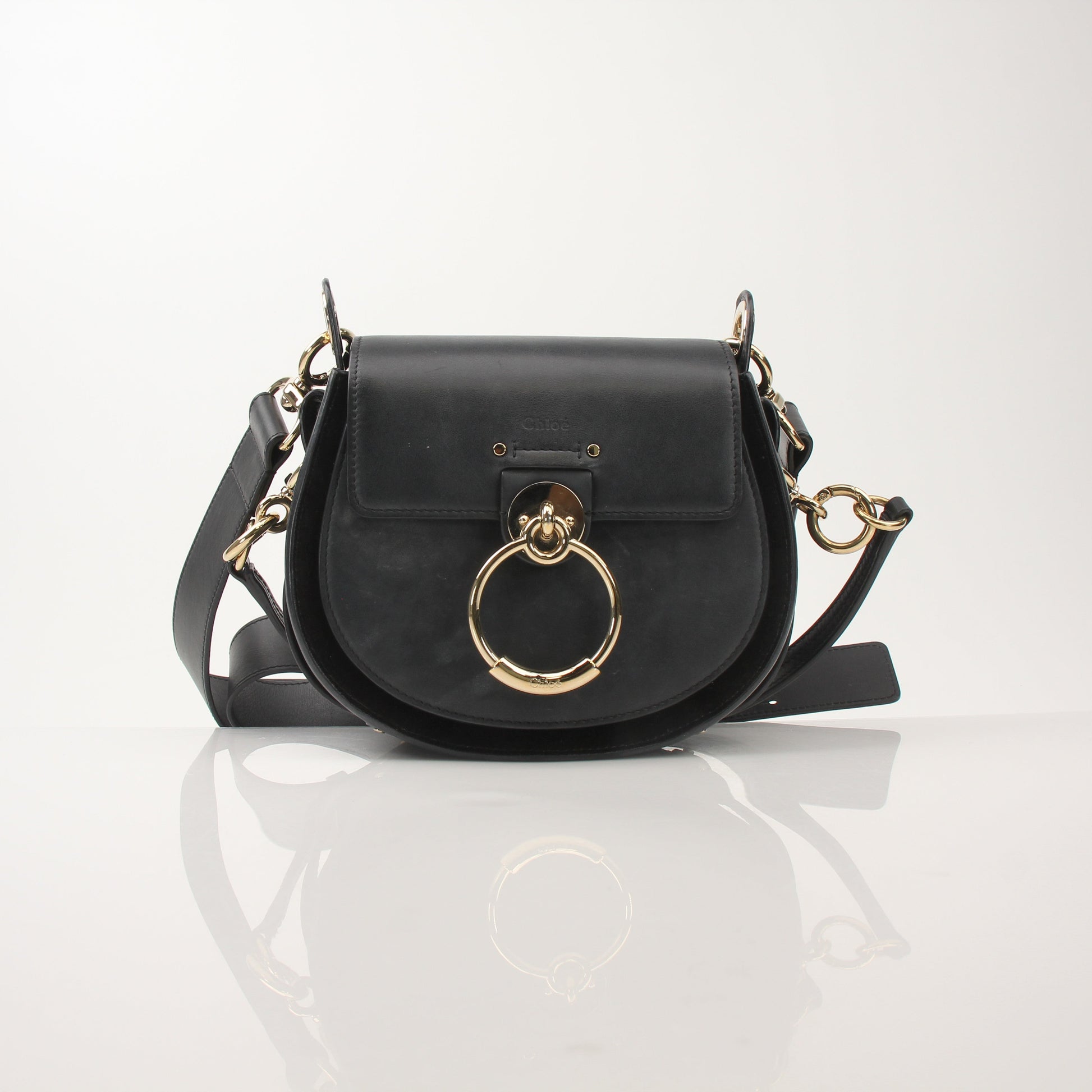 Gold & Beyond Chloé Tess Saddle Bag handbag with suede and leather details, featuring a curved shape and adjustable strap.