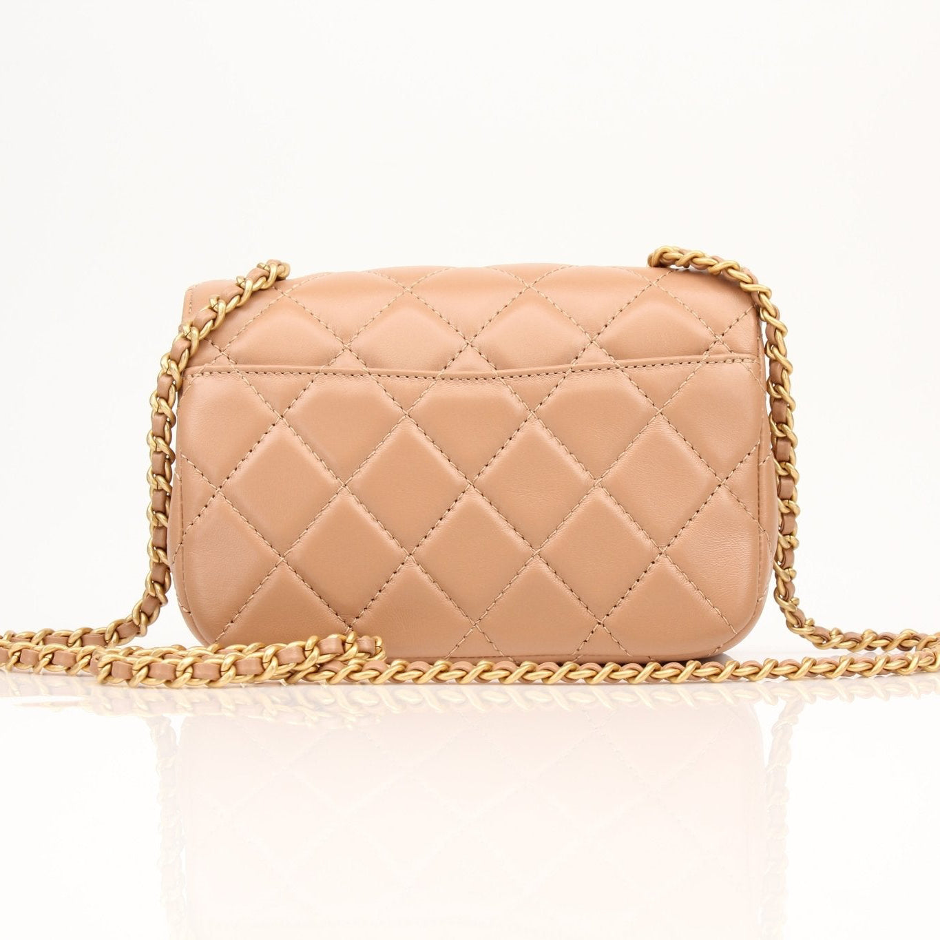 Gold & Beyond Chanel beige mini maxi handbag with top handle and gold accents, showcasing a stylish and compact design.