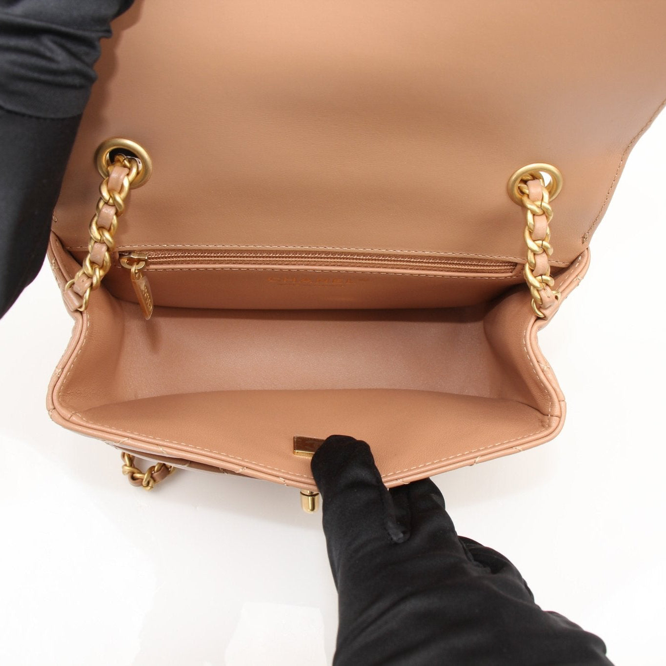Gold & Beyond Chanel beige mini maxi handbag with gold hardware, showcasing a stylish and compact leather handbag design.