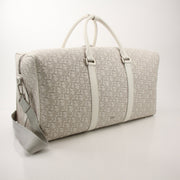 Christian Dior Lingot 50 duffle bag for travel, featuring sleek design and gold accents, displayed on a neutral background.
