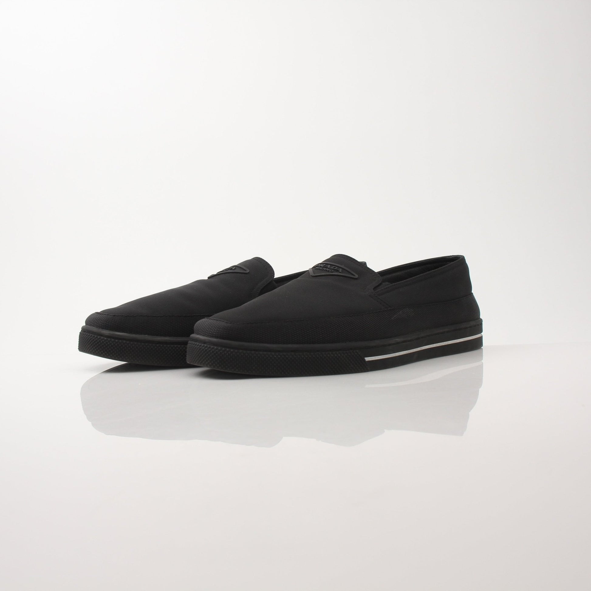 Prada men's triangle logo nylon slip-on loafers with sleek design and comfortable fit in black with logo detail.