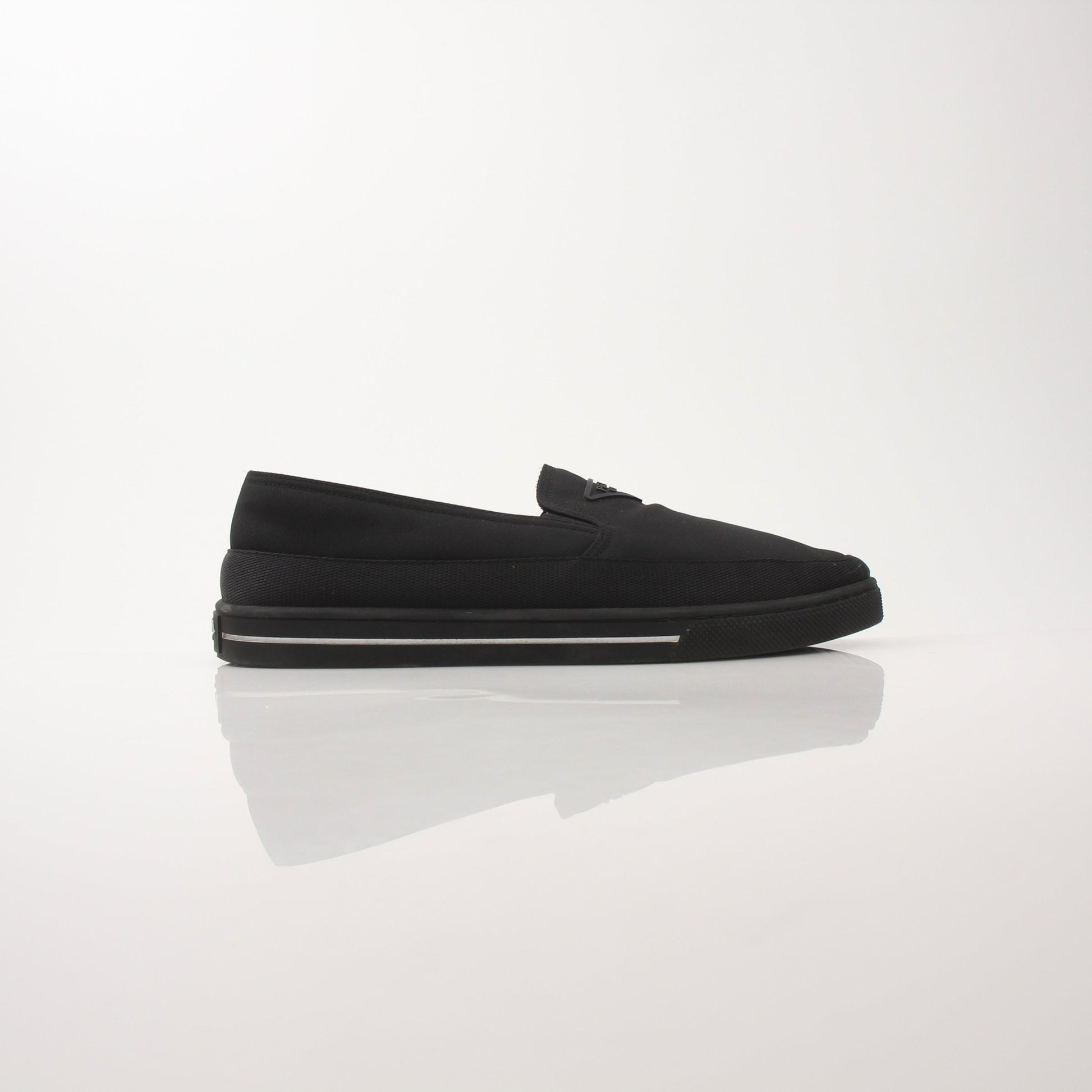 Prada men's triangle logo nylon slip-on loafers with sleek design and comfortable fit, featuring iconic logo detail.