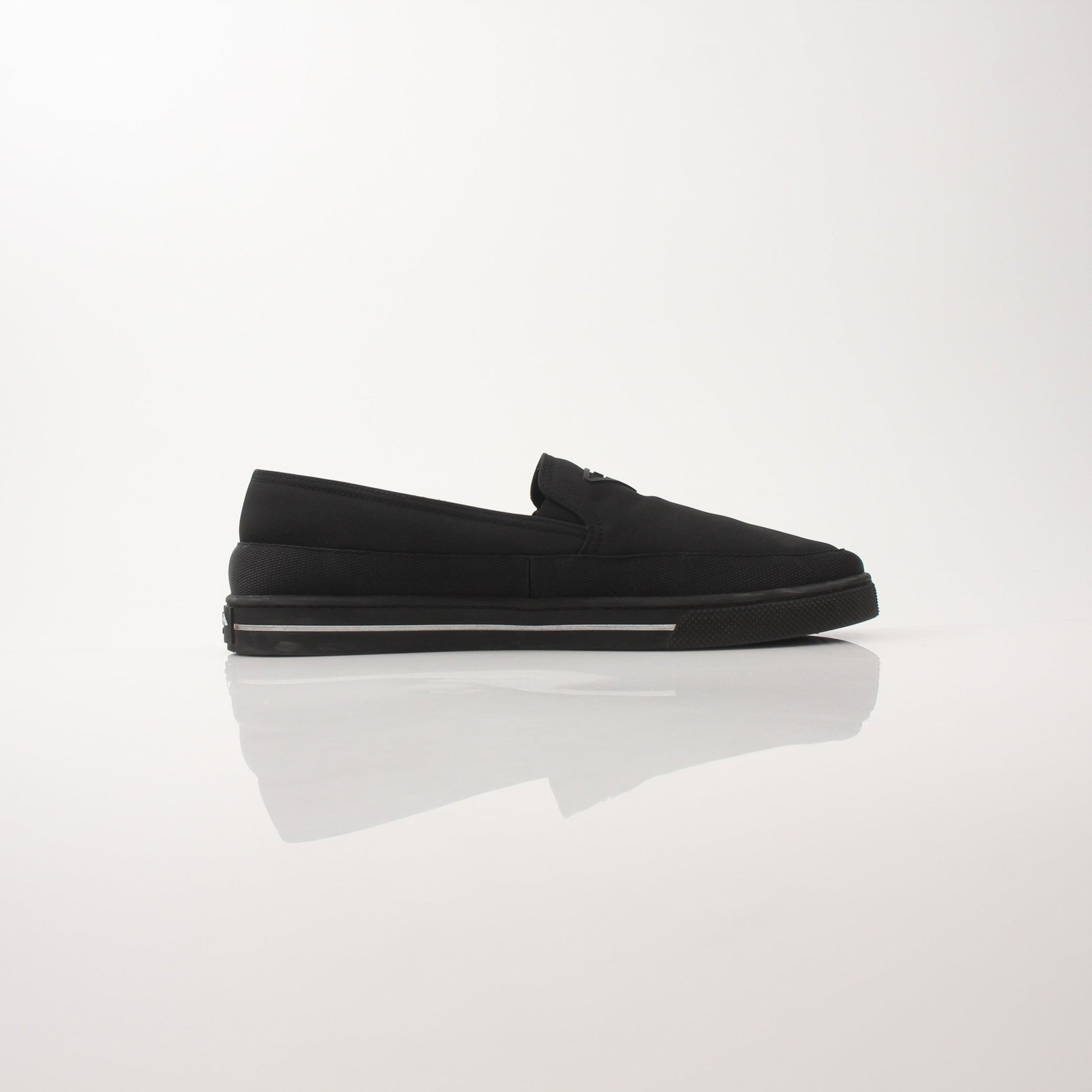 Prada men's triangle logo nylon slip-on loafers with sleek design and comfortable fit, photographed on a neutral background.