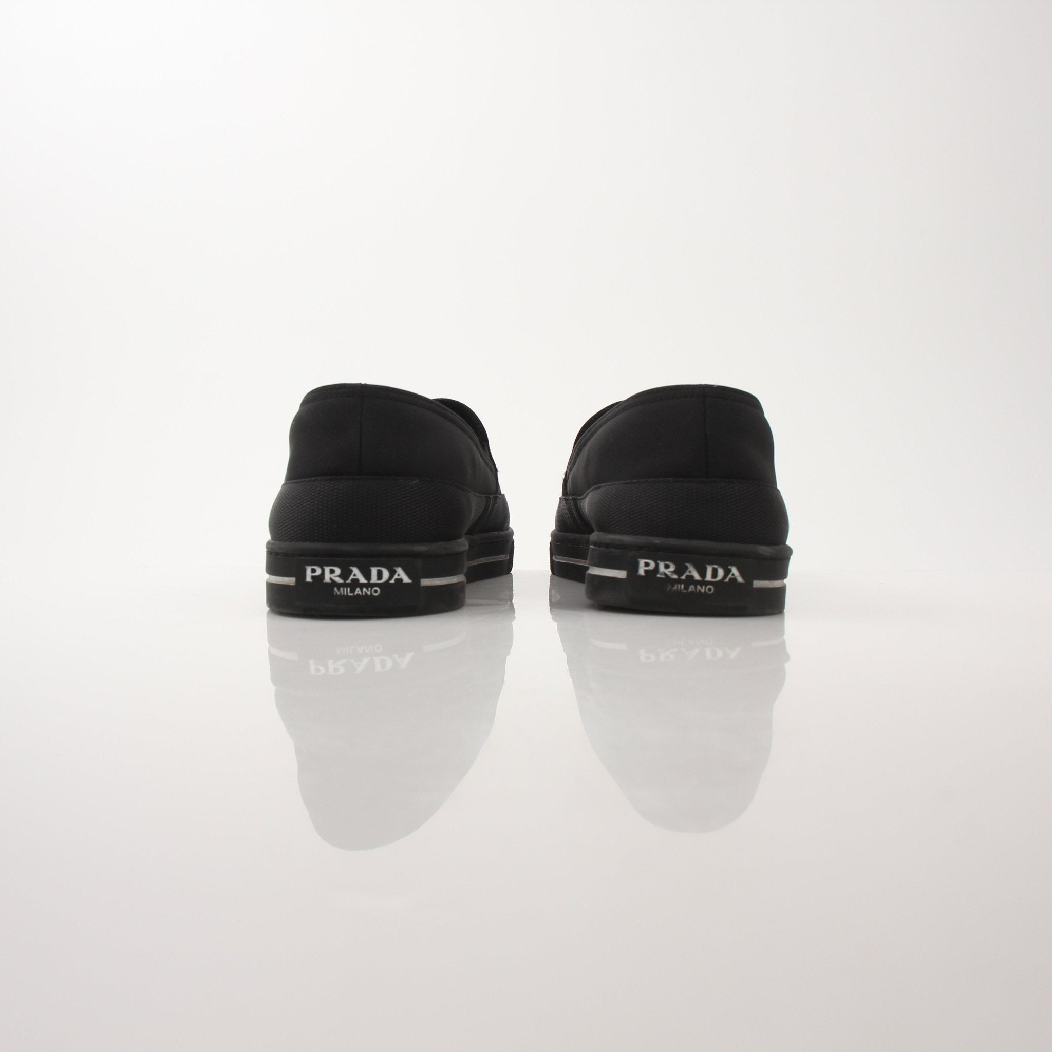 Prada men's triangle logo nylon slip-on loafers featuring sleek design and comfortable fit, ideal for casual and stylish wear.