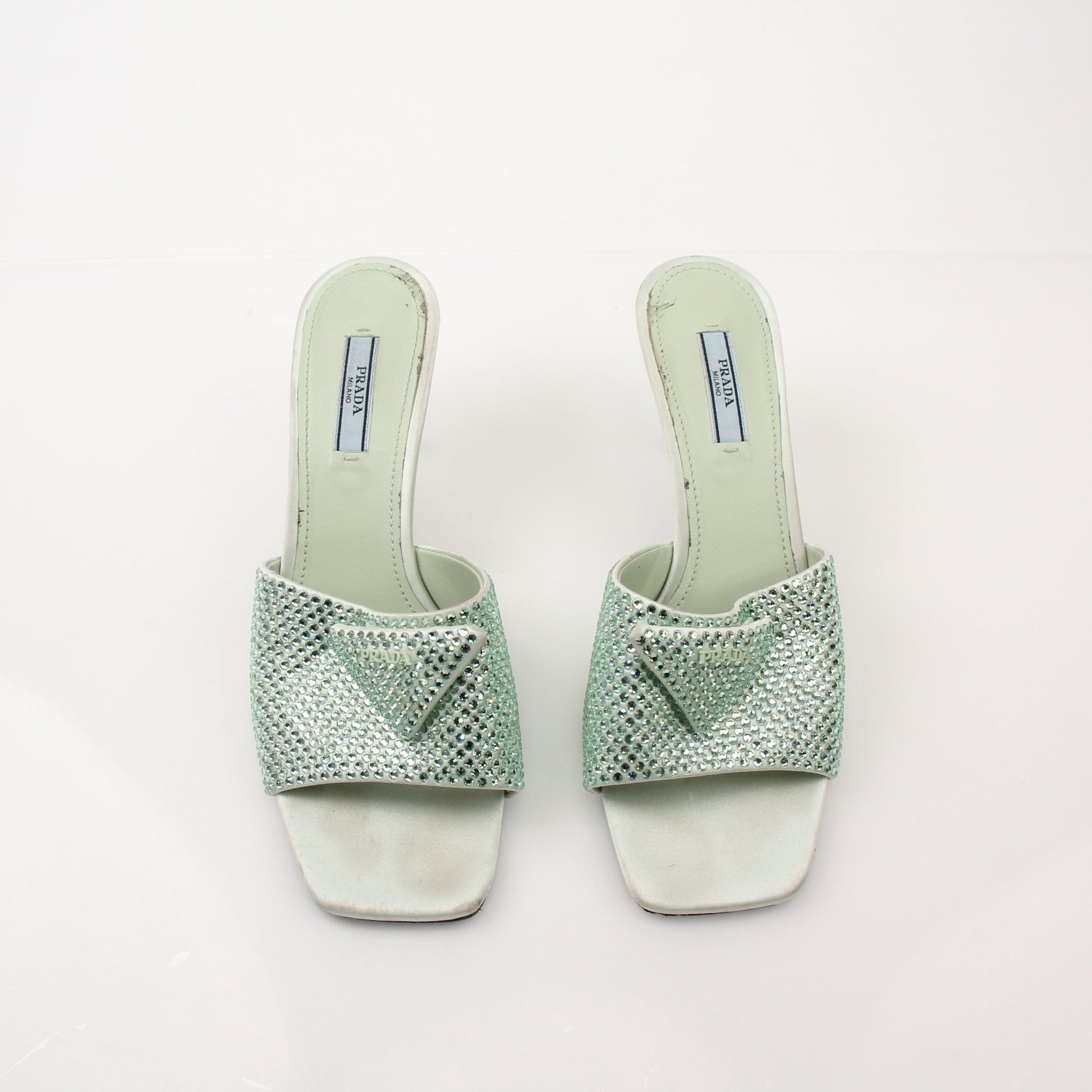 Prada women's crystal-embellished open-toe mules, luxury heels with sparkling details and elegant design, on a neutral background.