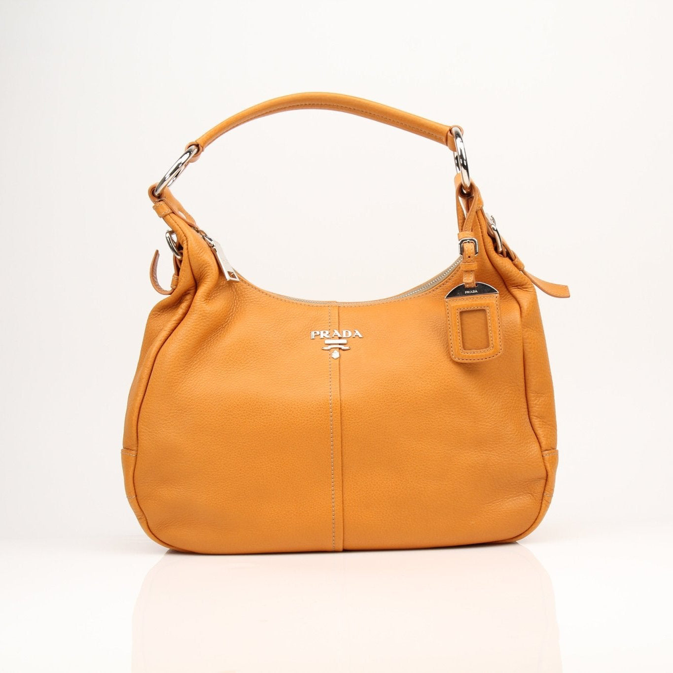Prada orange Daino leather handbag with sleek design and top handle, stylish and luxurious accessory.