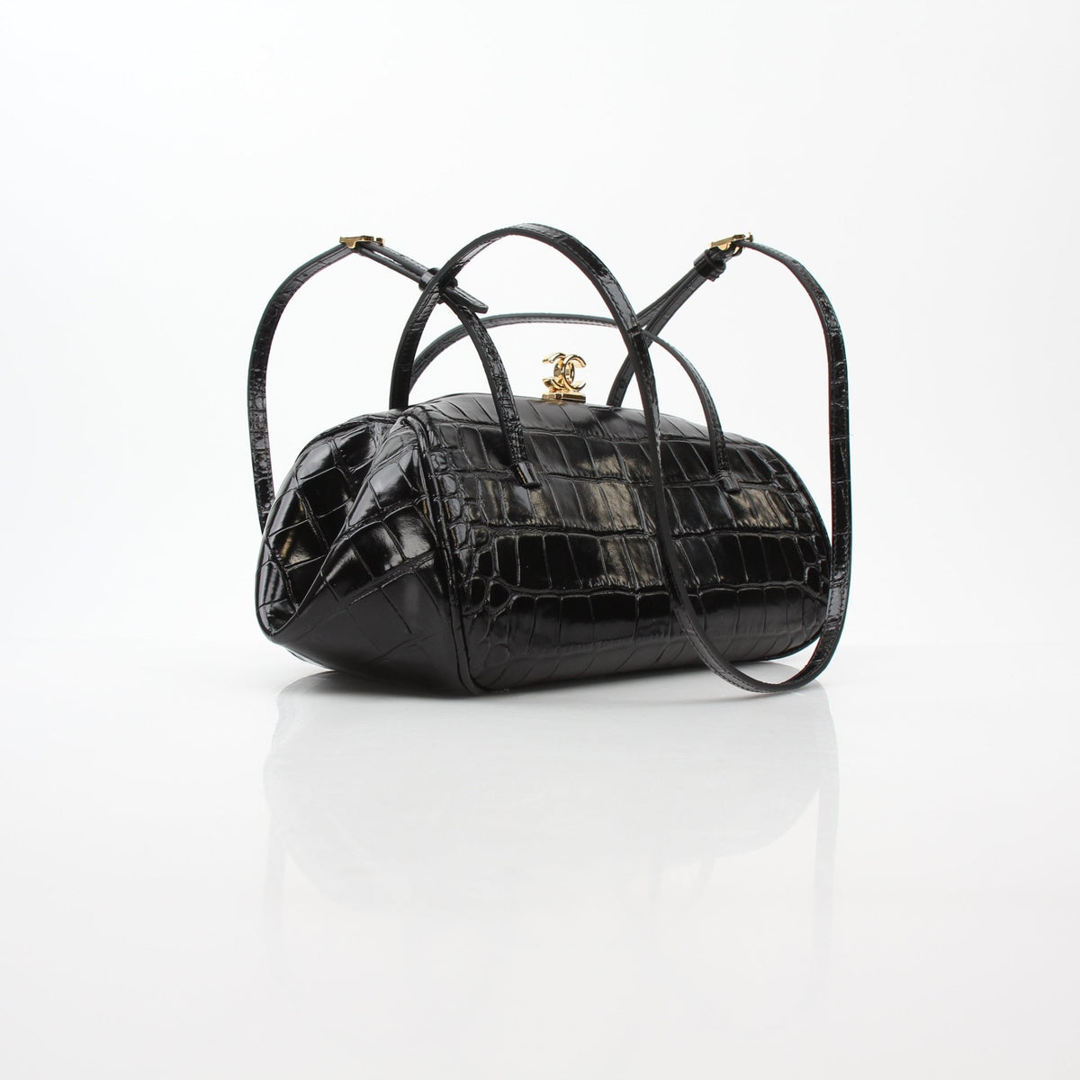 Black Chanel Pretty CC croc-embossed barrel handbag with gold hardware, featuring top handles and a structured shape.