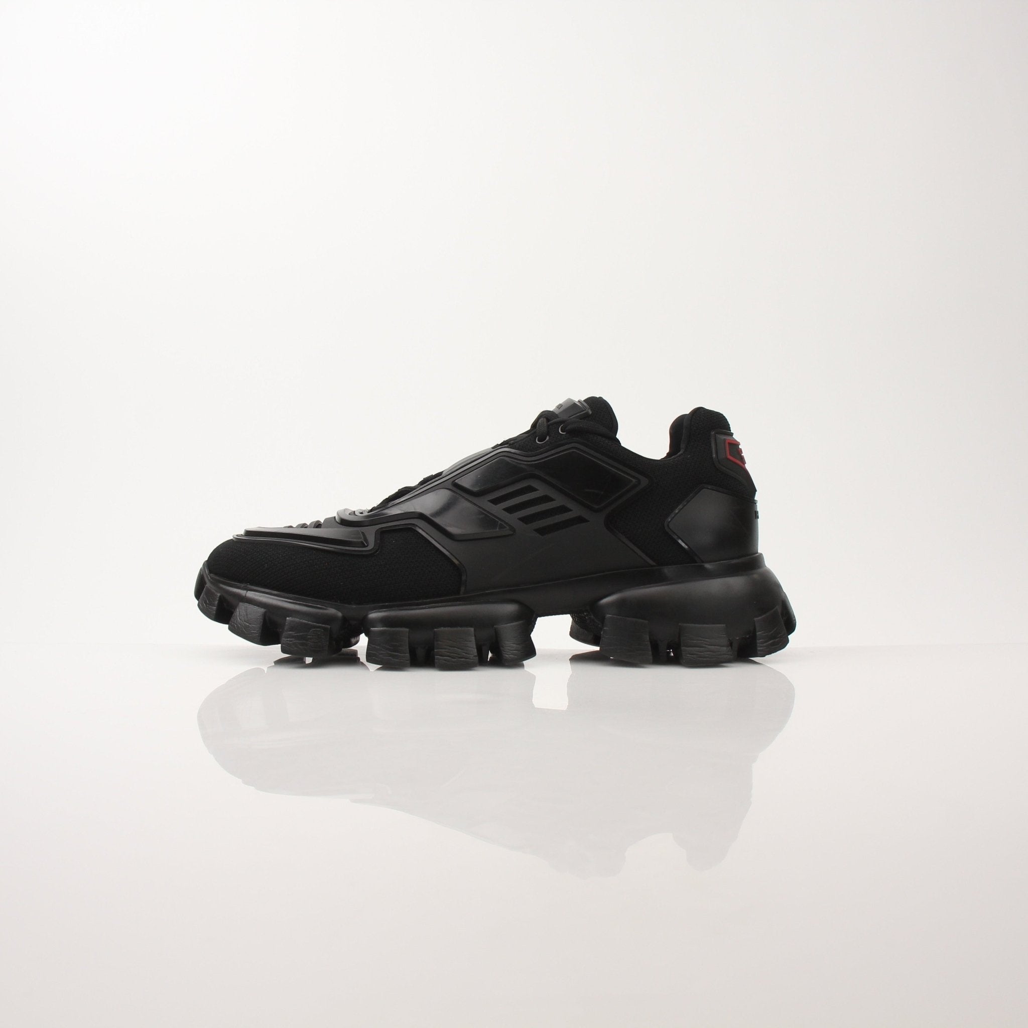 Prada men's Cloudbust Thunder knit fabric sneakers with white and black design, showcasing athletic shoes by Gold & Beyond.
