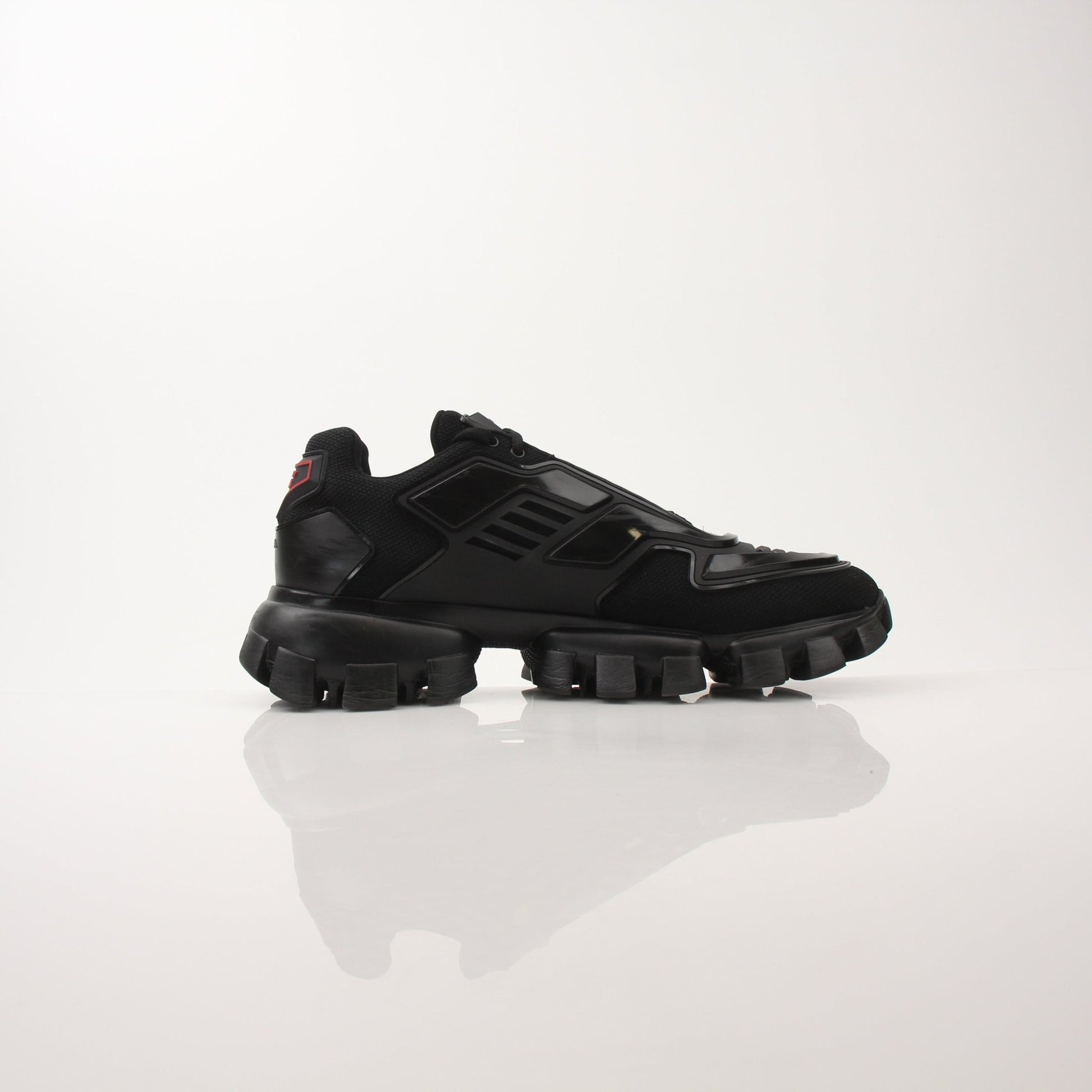 Gold & Beyond Prada Men’s Cloudbust Thunder knit fabric sneakers with white soles and modern design.