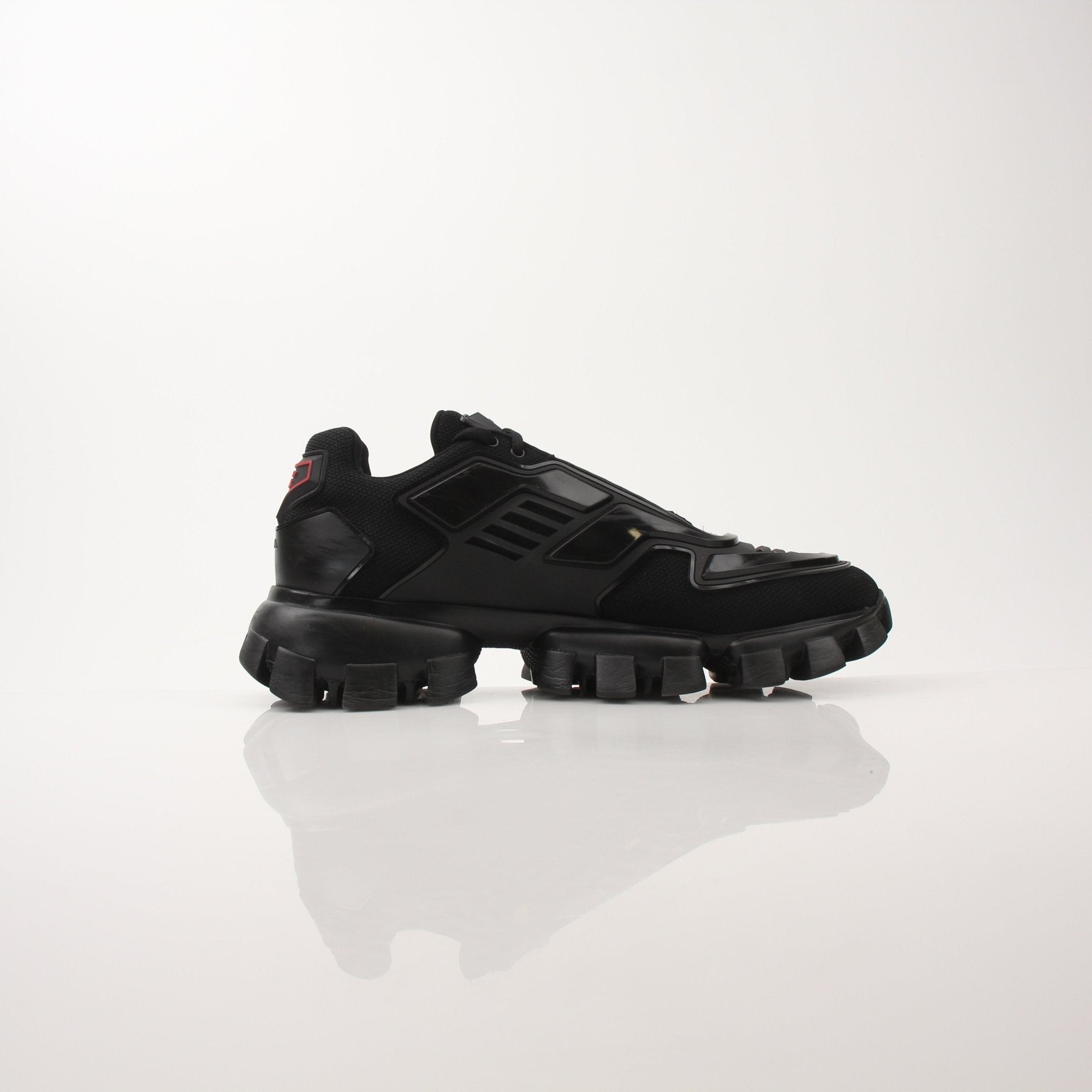 Gold & Beyond Prada Men’s Cloudbust Thunder knit fabric sneakers with white soles and modern design.