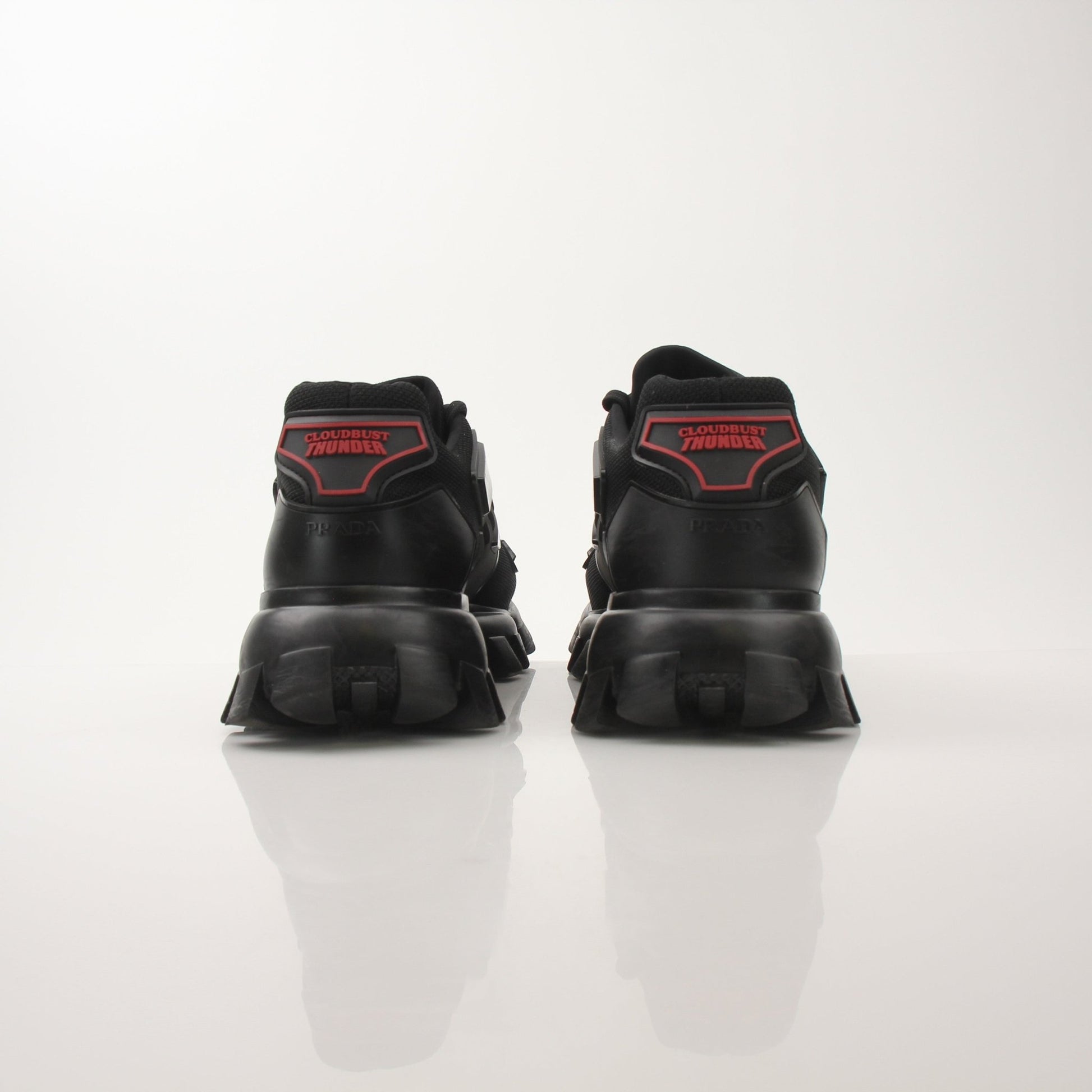 Prada Men’s Cloudbust Thunder knit fabric sneakers in black and white with chunky soles, designed for sporty casual wear.