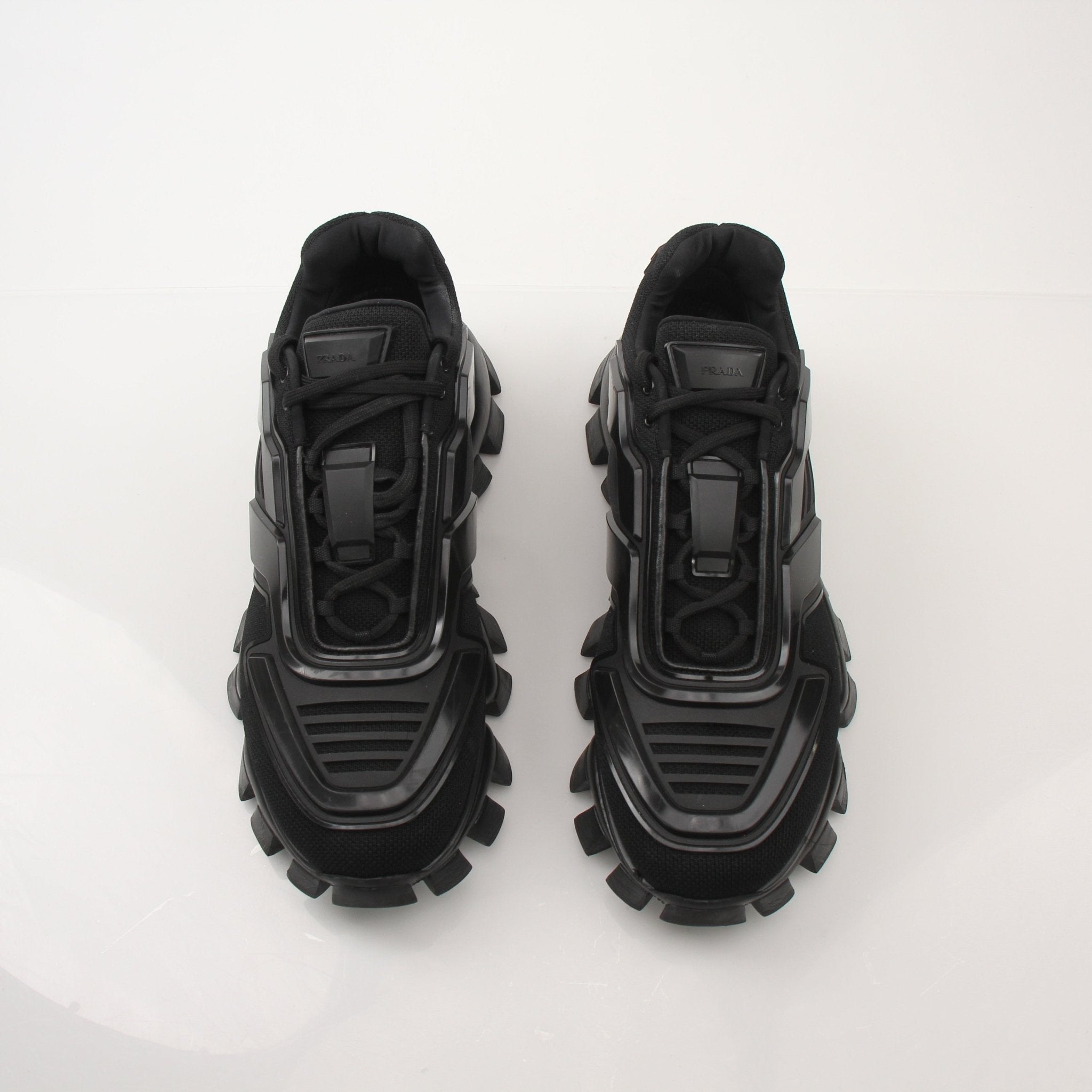 Prada Men’s Cloudbust Thunder knit fabric sneakers in black with white soles, showcasing sporty design and branded details.