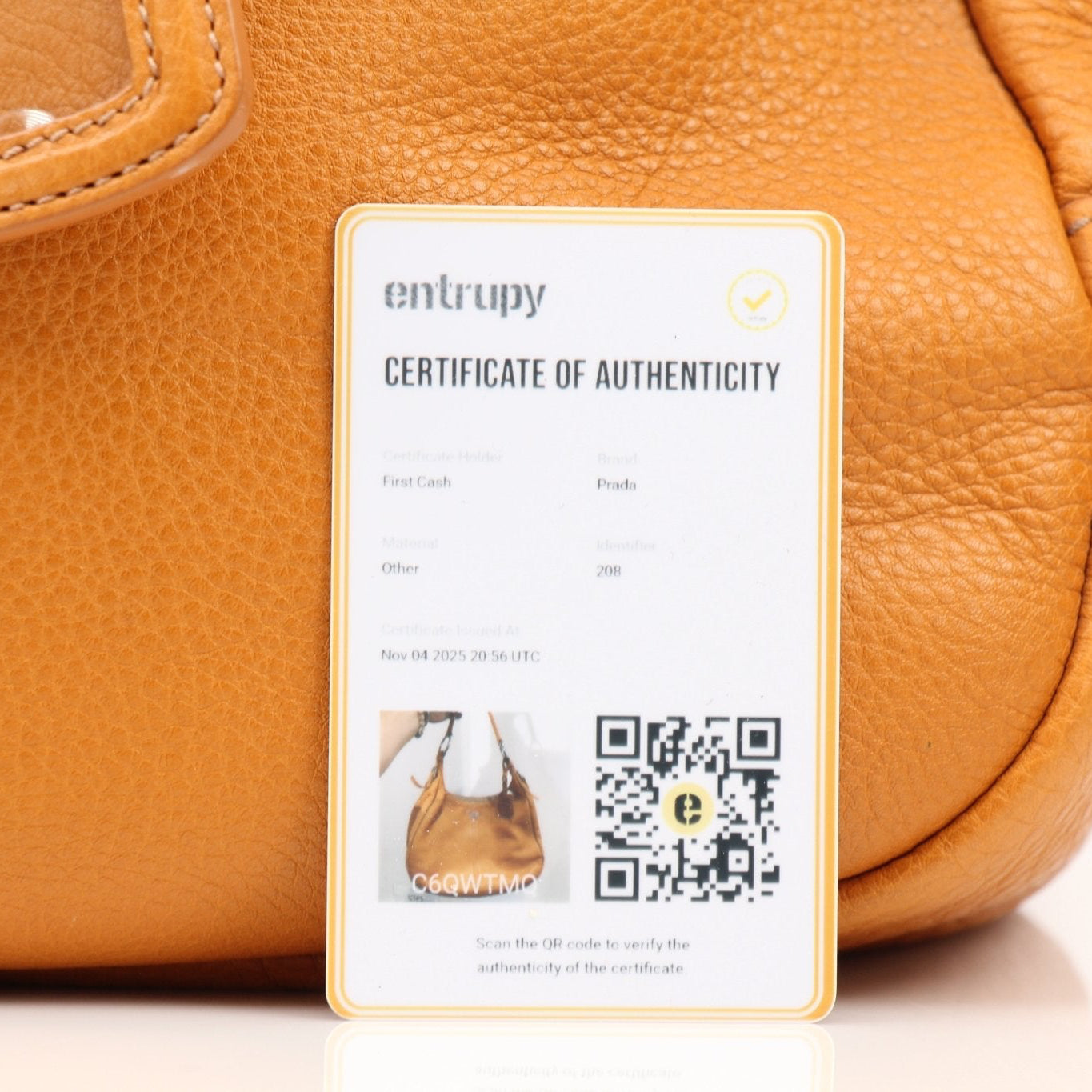 Prada orange Daino leather handbag with sleek design and structured shape, showcasing its luxurious craftsmanship.