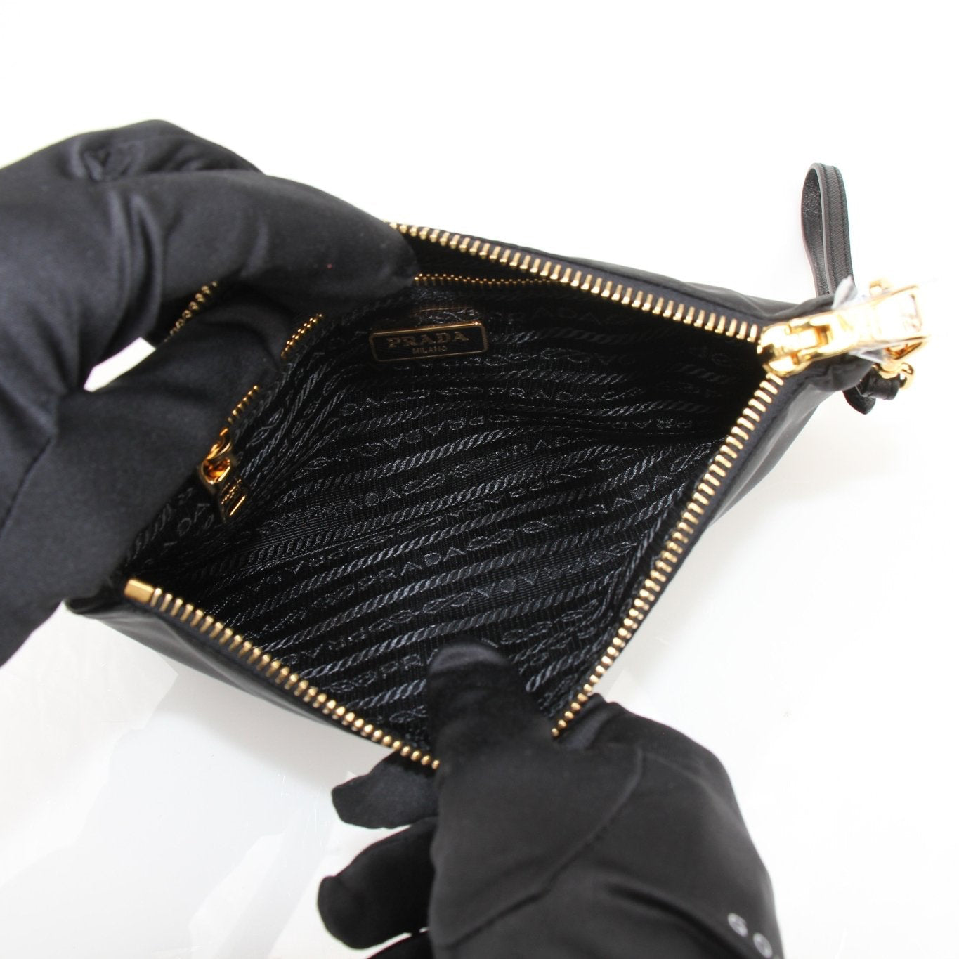 Prada black Re-Nylon wristlet with top zipper closure and sleek design, perfect for carrying essentials.